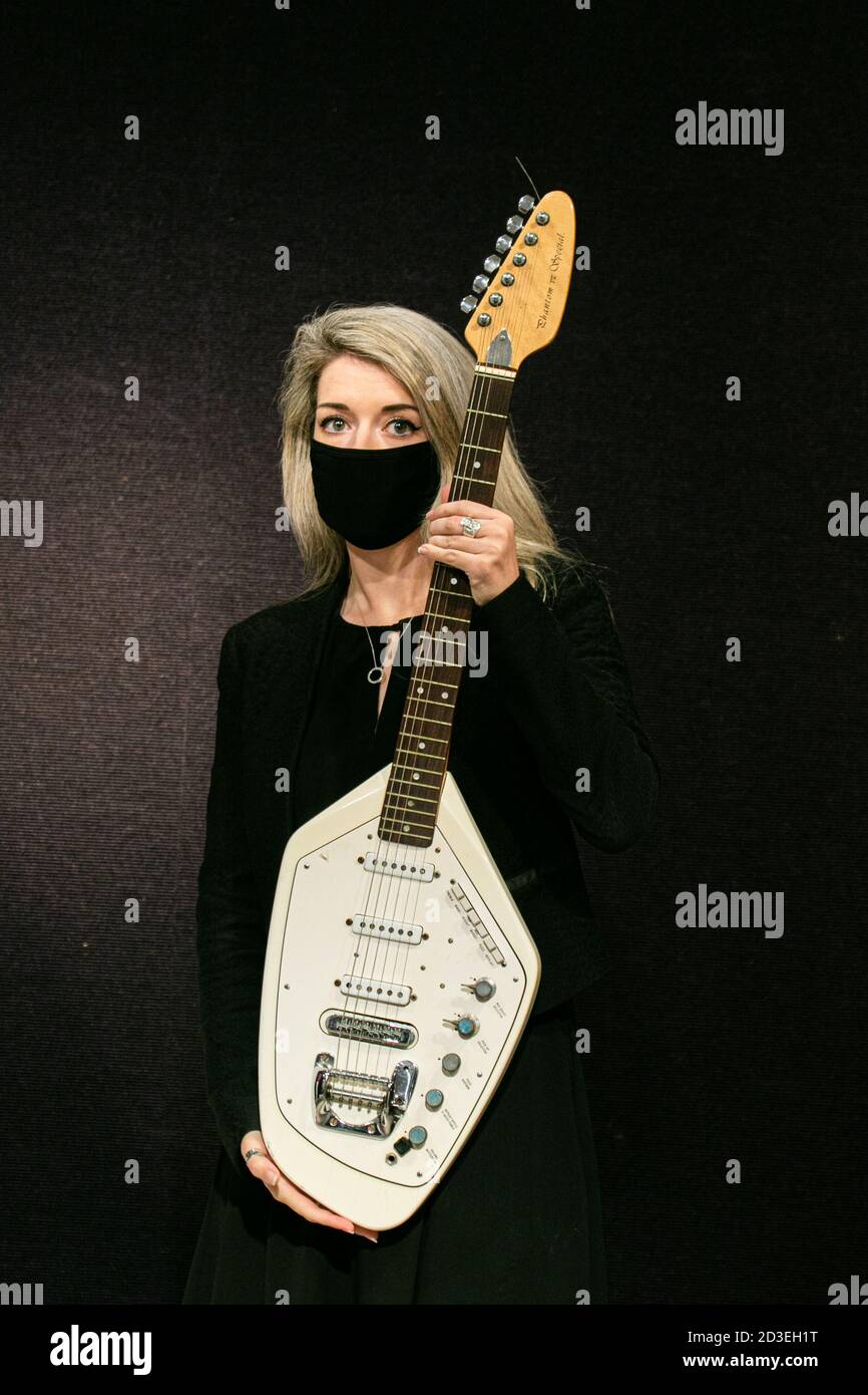 BONHAMS KNIGHTSBRIDGE LONDON,UK October 2020. A Bonhams assistant holds: Joy  Division. The Vox Phantom VI Special Guitar owned by Ian Curtis and played  in the video for 'Love Will Tear Us Apart',