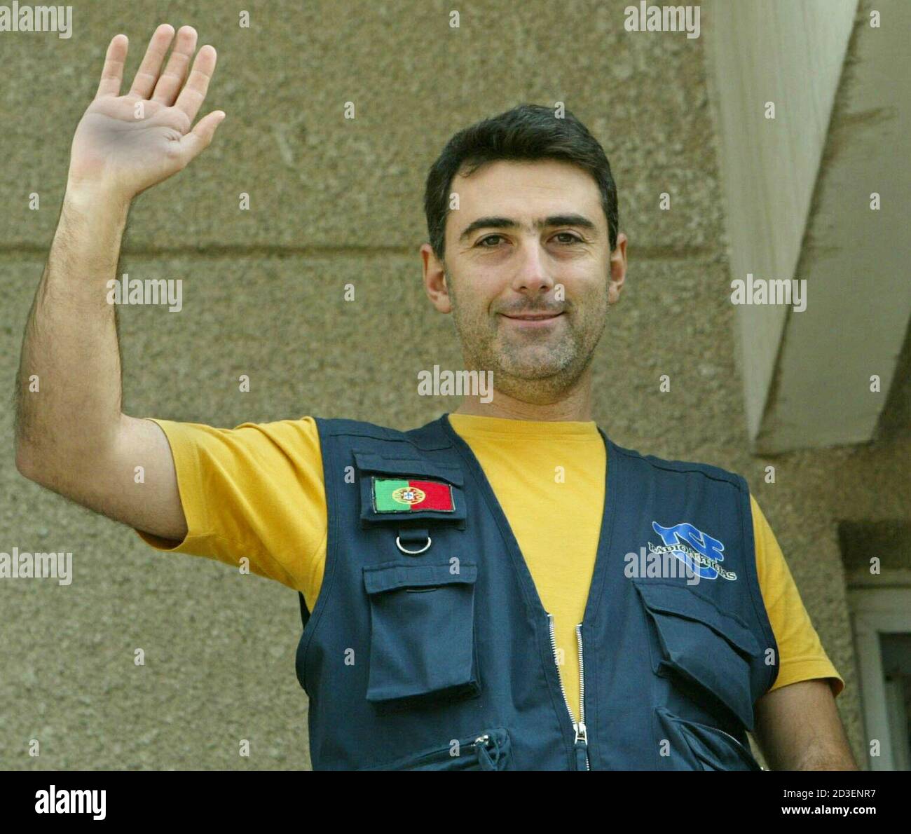 Portuguese radio reporter Carlos Saleiras waves from his hotel balcony in  Basra November 16, 2003. Raleiras, who works for Portuguese private radio  station TSF, was released unharmed on Saturday after being kidnapped