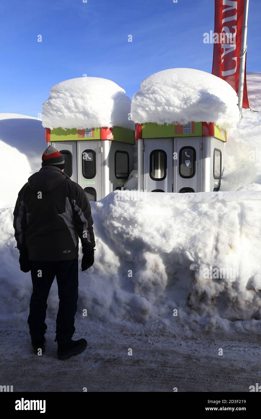 Man looking at telephone boxes in snow, Seefeld, Tirol, Austria, winter, Central Europe Stock Photo