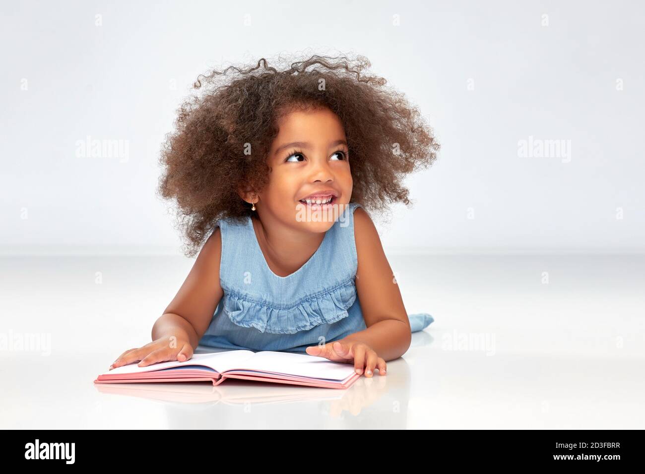 smiling little african american girl reading book Stock Photo - Alamy