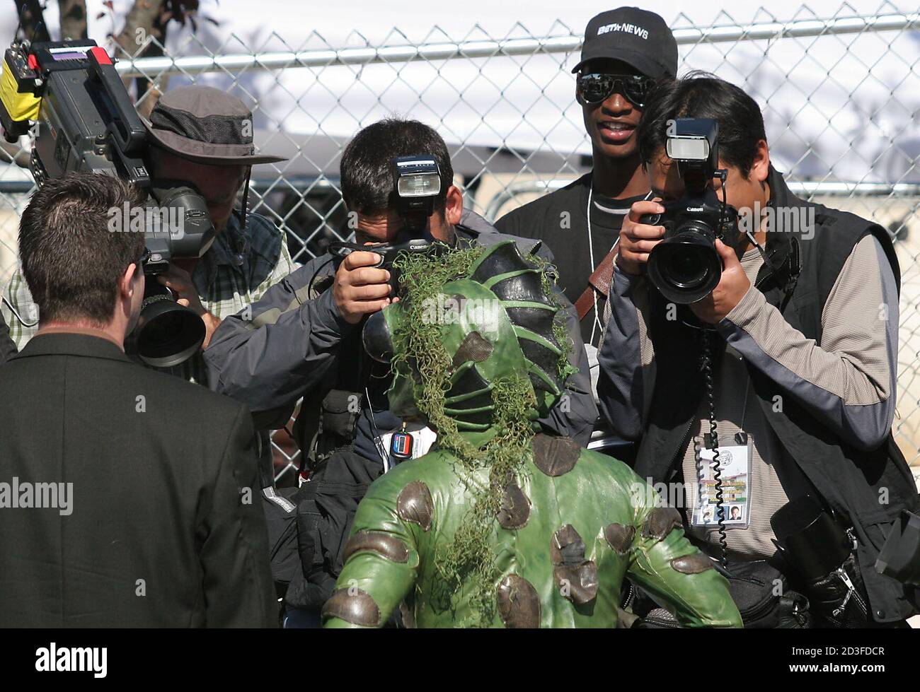 News Cameramen Try To Get A Shot Of A Guy Dressed Up In A Frog Suit In