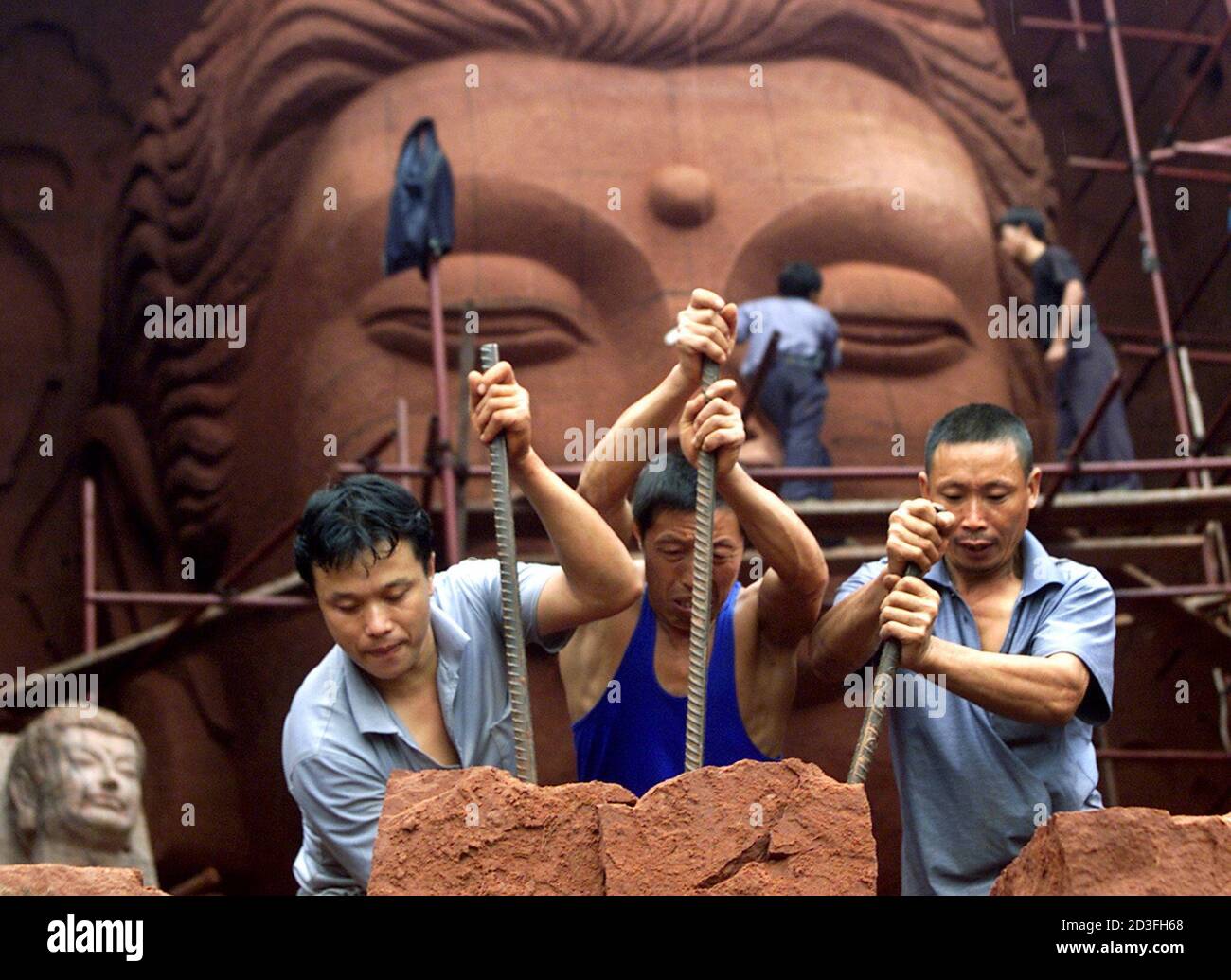 Chinese farmers build a replica of Afghanistan's Bamiyan Buddha statue at Leshan, in China's southwest Sichuan province September 20, 2001. A private Chinese company is creating replicas of the two figures that once stood in Afghanistan's Bamiyan Valley for 1,500 years. The statues were blown up by the Taliban regime in early March. One statue will be a life-size copy of the shorter Buddha, about 37 meters high, and the other a half-size replica of its 53-meter twin. The $200,000 project is scheduled for completion in May of next year. The taller figure has one noticeable flourish: a face. The Stock Photo