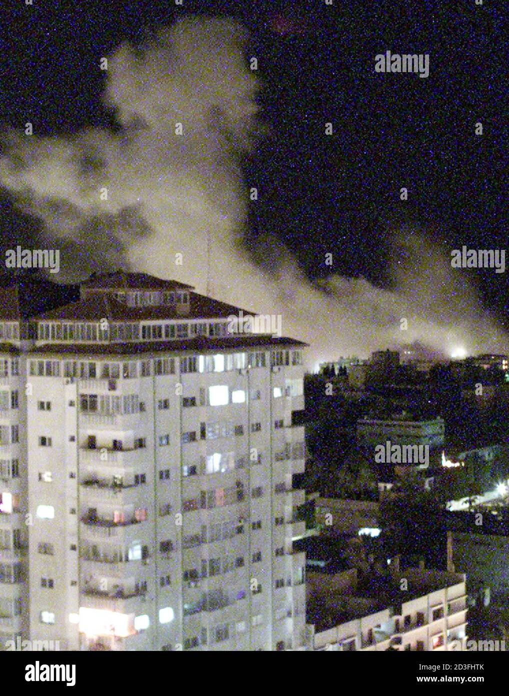 Smoke rises over Palestinian police headquarters after it was hit by missiles from Israeli warplanes in the Gaza Strip December 14, 2001. Israeli F-16 fighter planes dropped at least two bombs on a Palestinian security target in Gaza City on Friday, in the latest retaliatory military strike for a wave of Palestinian attacks. REUTERS/Suhaib Salem SJS Stock Photo