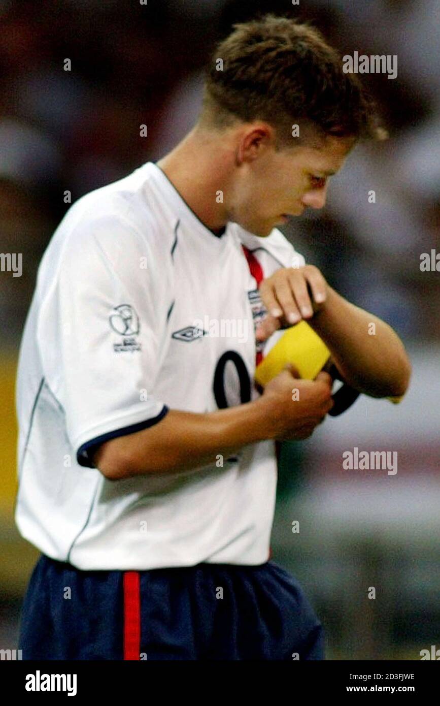 England's Michael Owen adjusts the captain's armband after he received it  from David Beckham in the second half of their group F match against Sweden  at the World Cup Finals in Saitama