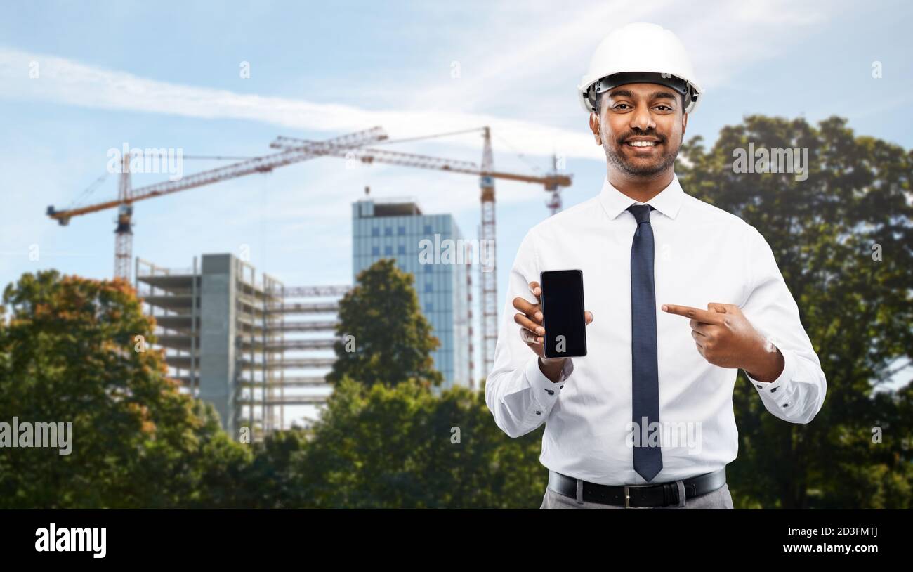 architect showing smartphone at construction site Stock Photo