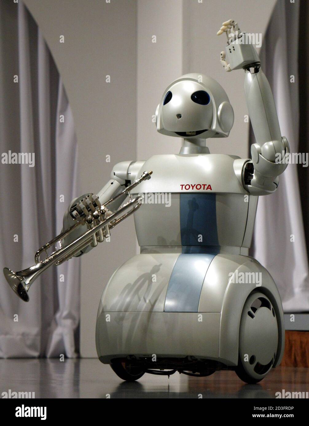 Toyota Motor Corporation's new rolling partner robot waves as it goes on  stage at a news conference in Tokyo March 11, 2004. Toyota announced on  Thursday a project to develop partner robots