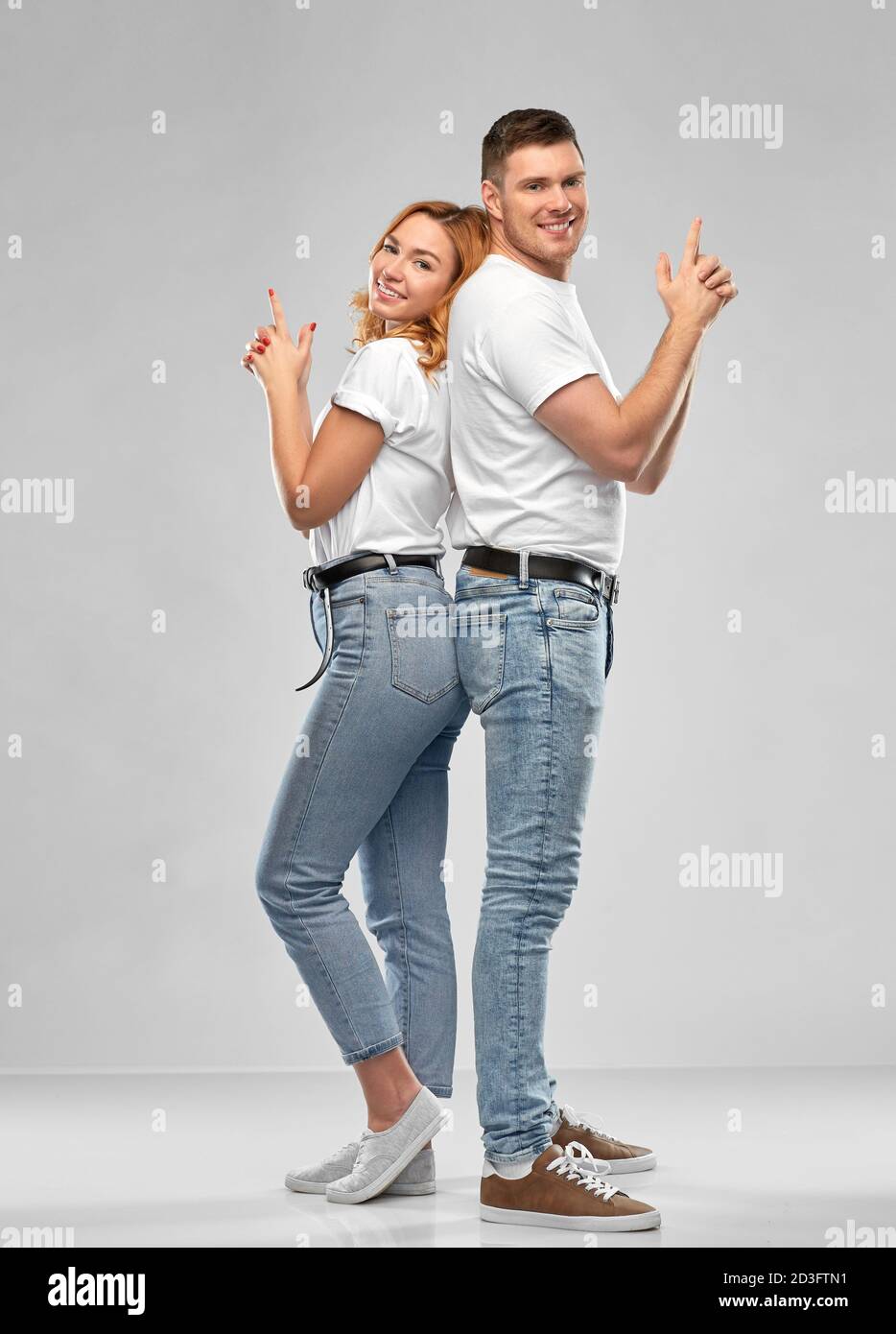 couple in white t-shirts shirts making gun gesture Stock Photo