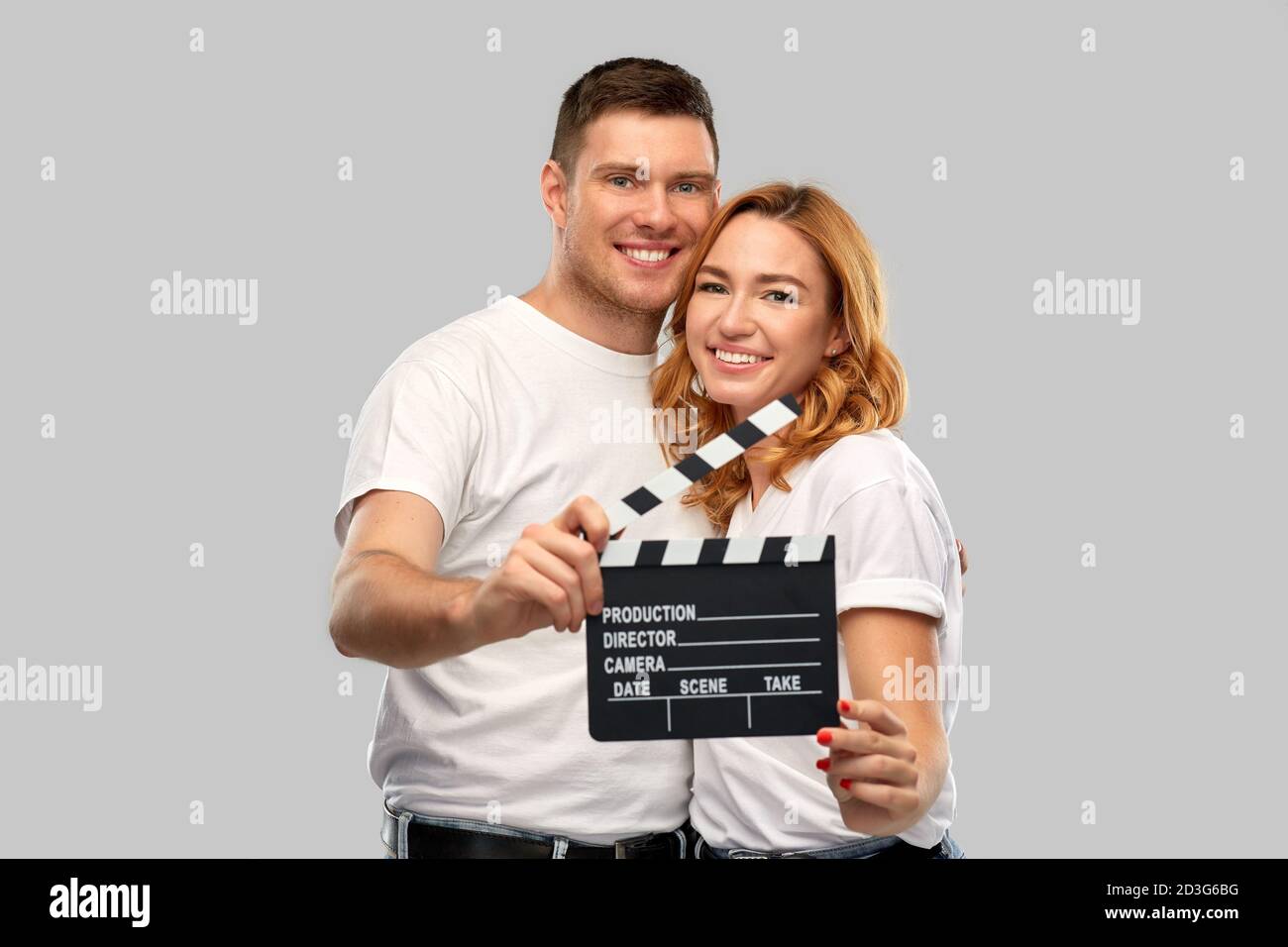 happy couple in white t-shirts with clapperboard Stock Photo