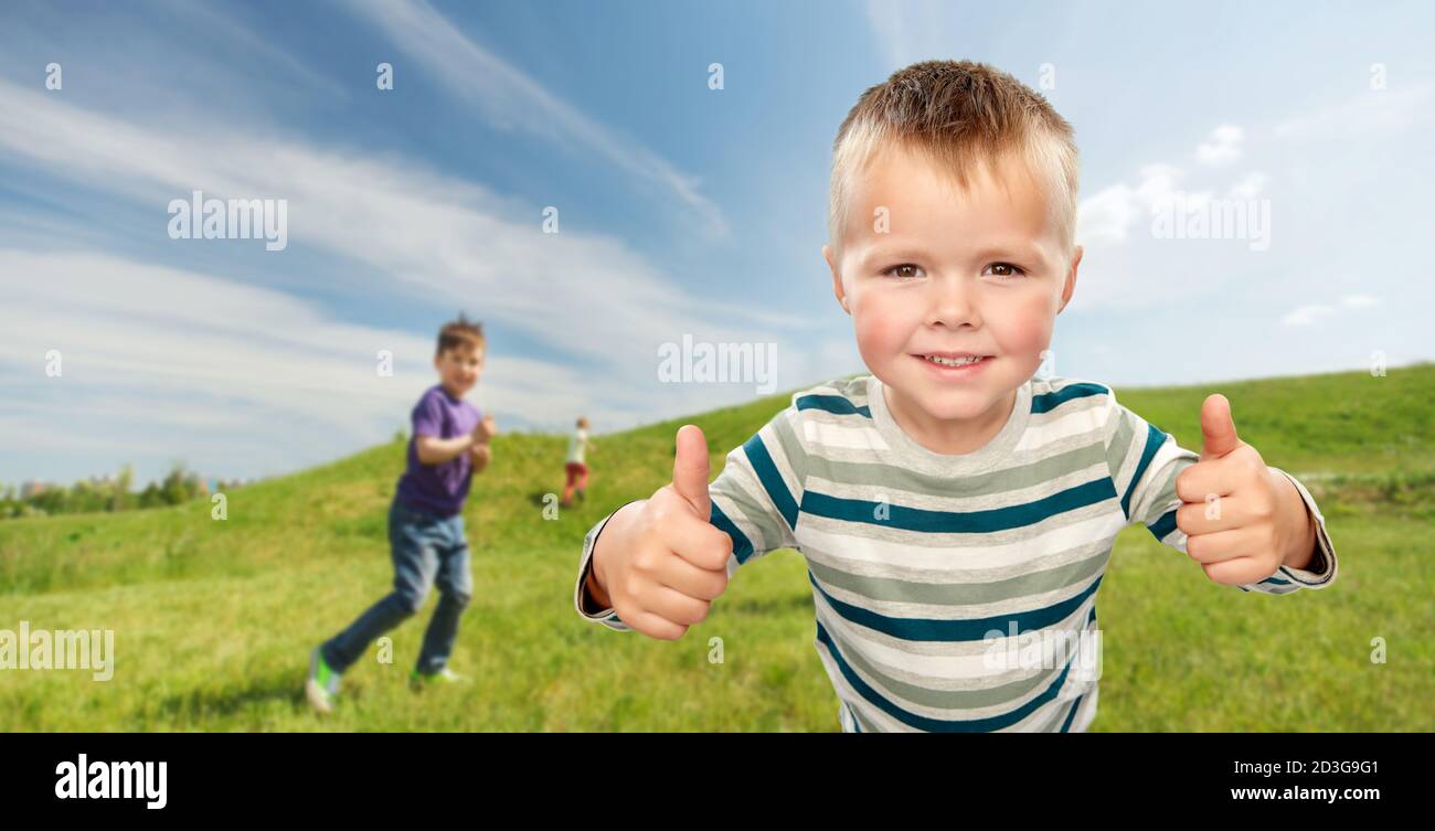 smiling boy showing thumbs up outdoors Stock Photo - Alamy