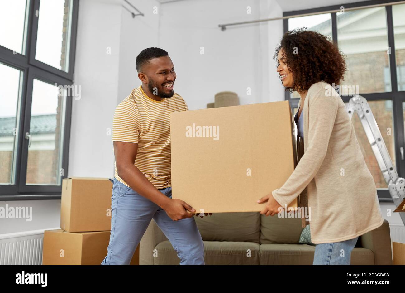 happy couple with boxes moving to new home Stock Photo - Alamy