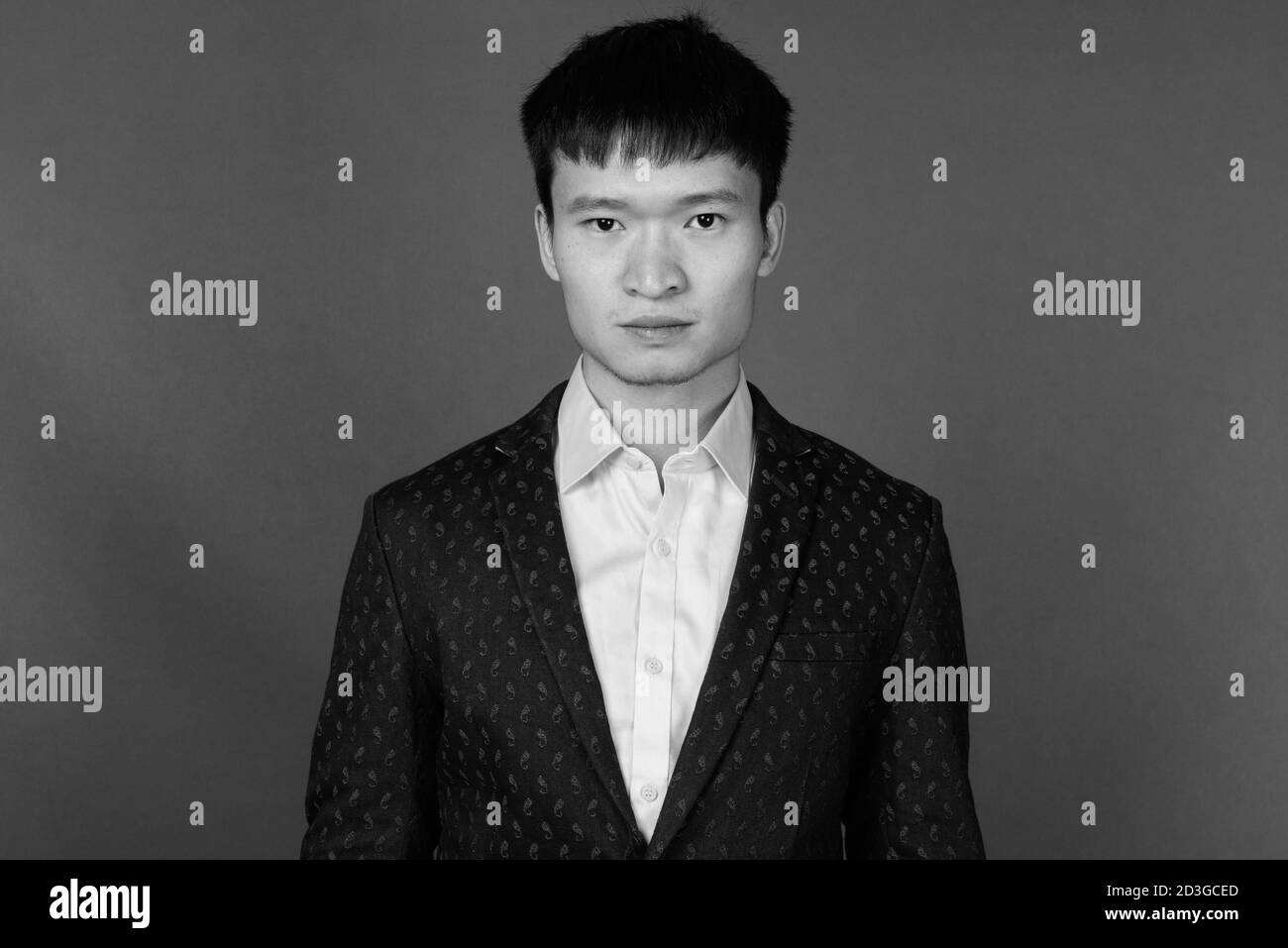 Portrait of young Chinese businessman against gray background Stock Photo