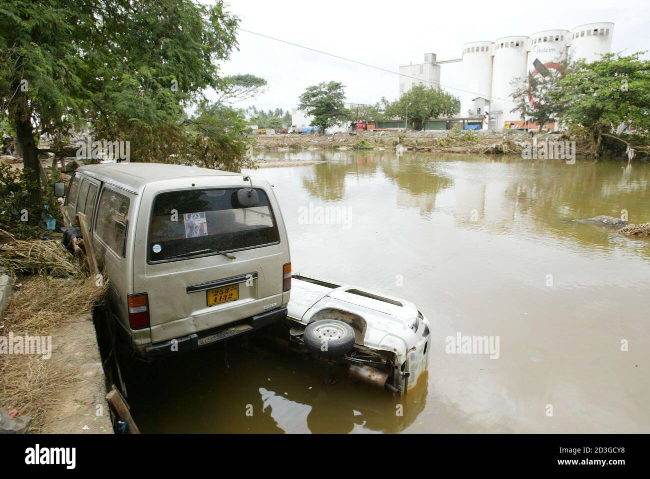 Damaged vans lie on a flooded street in Unawatuna, 6 km (3.7 miles) south  of Galle, Sri Lanka December 28, 2004 after a tsunami hit the area over the  weekend. Nations on