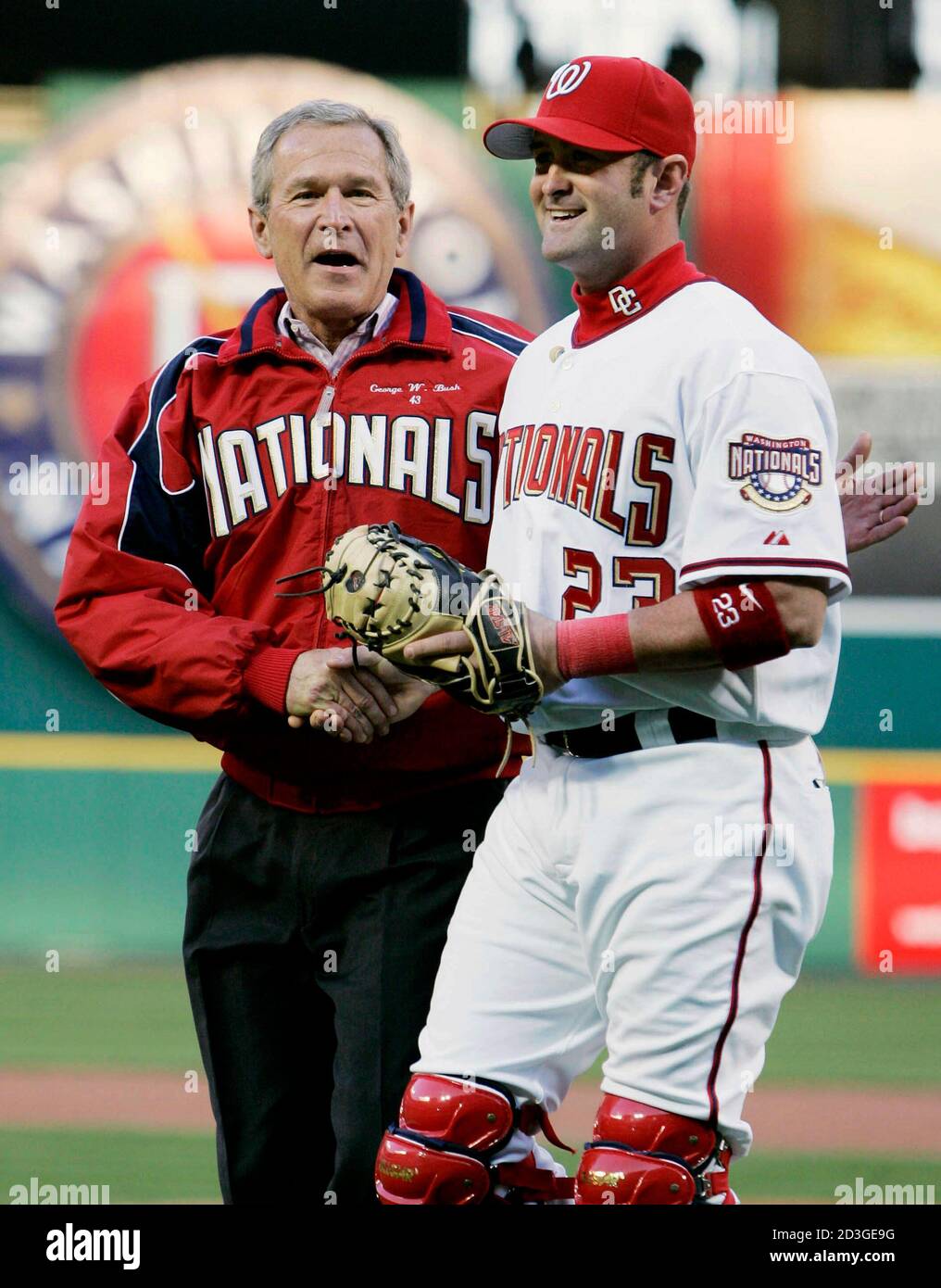 U.S. President George W. Bush shakes hands with catcher Brian Schneider after throwing out the first pitch for the home opener for the Washington Nationals at RFK Stadium in Washington, April 14, 2005. Bush was greeted by cheers from an estimated 48,000 fans who packed into Washington's Robert F. Kennedy Memorial Stadium to witness the historic return of the iconic American sport to the U.S. capital. REUTERS/Larry Downing  LSD/SV Stock Photo