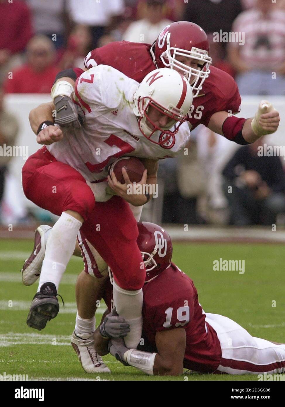 Nebraska's Eric Crouch, 7, is stopped by Oklahoma's Michael Thompson, 19, and Rock Calmus during fourth quarter action, in Norman, Oklahoma, October 28, 2000. Oklahoma defeated Nebraska 31-14.  TK/RCS Stock Photo