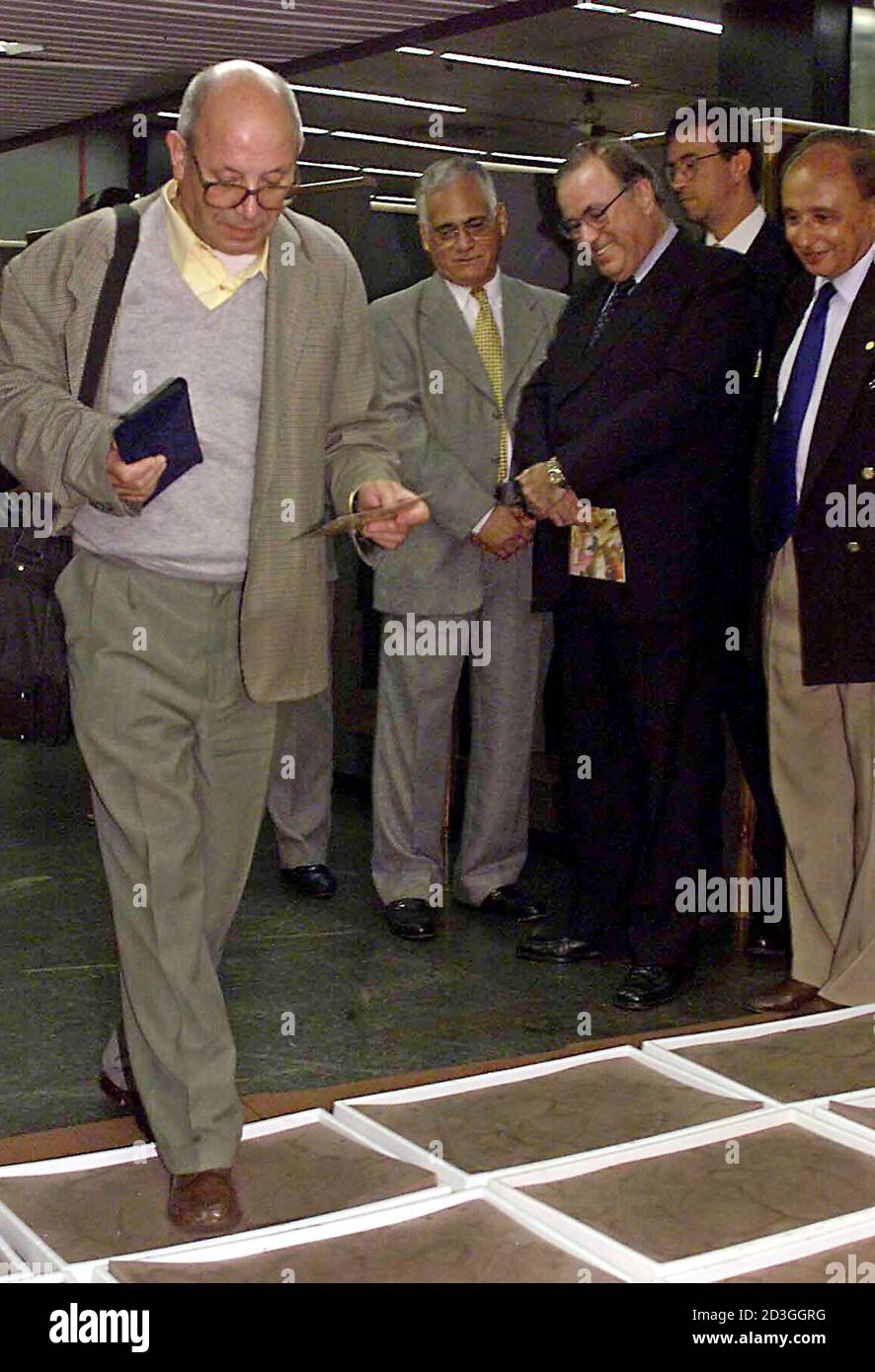 Brazil's Minister of Agriculture Marcos Vinicius Pratini de Moraes (3rd L) watches as a passenger arriving from Portugal walks through an iodine foot bath at the Galeao international airport in Rio de Janeiro March 19, 2001. For the first time, passengers arriving from Europe will be subjected to the preventative footbaths, whose iodine solution should kill micro-organisms that would cause 'foot-and-mouth' disease.  GN/SV Stock Photo