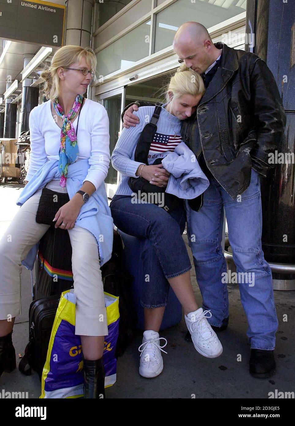Chantal Blok (L) looks on as her friend Marion Cote (C) is comforted by her  husband Leon Guit after learning about the terrorist attacks in New York  and Washington. The trio, all