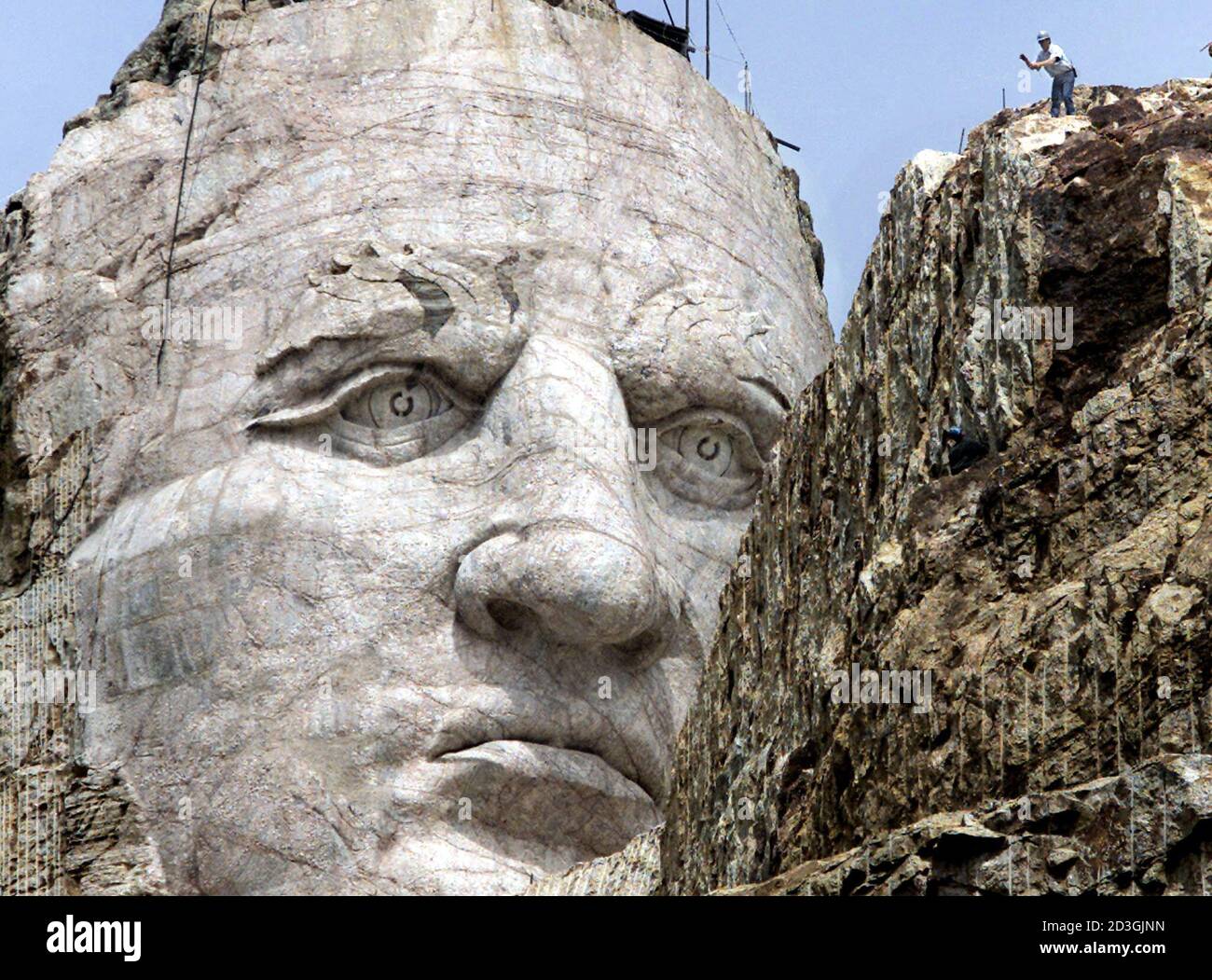 PHOTO TAKEN 26JUN01 - A workman (R) is dwarfed by the carved face of Lakota  warrior Crazy Horse standing 90 feet (27-meters) tall in the Black Hills of  South Dakota. The