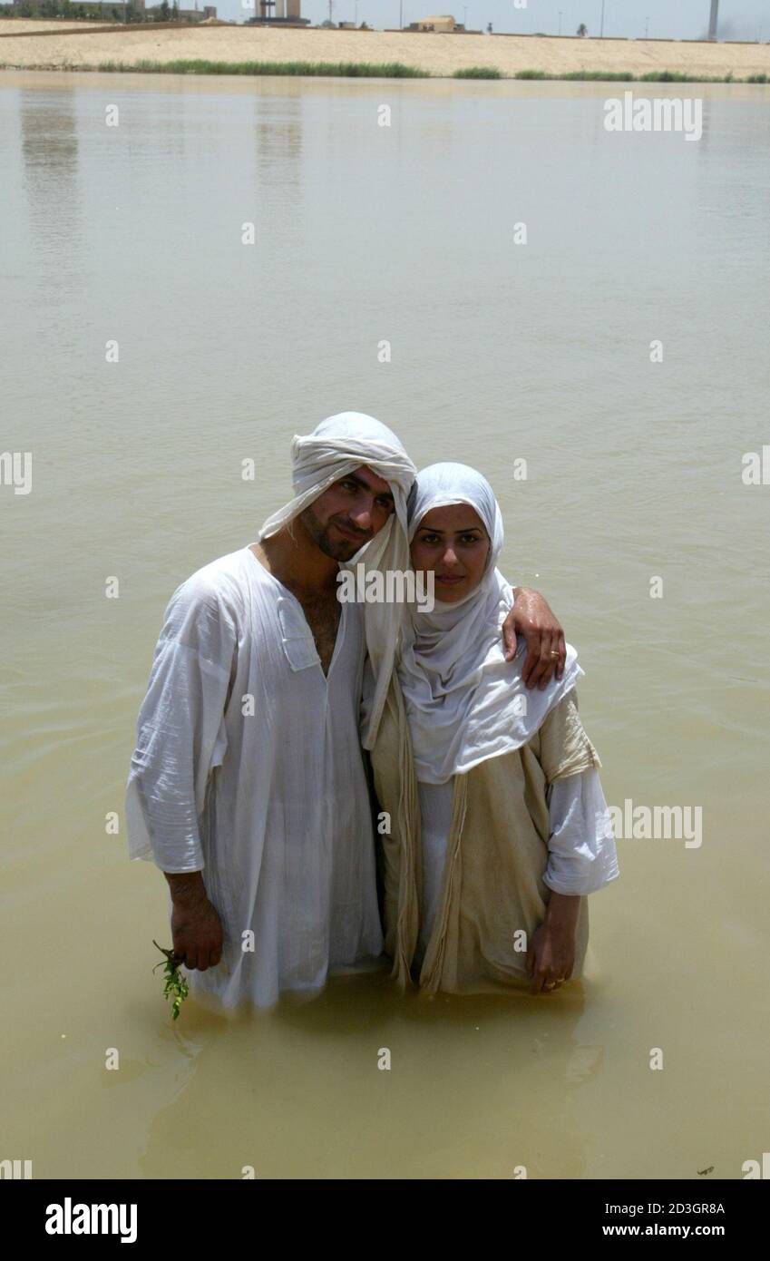 An Iraqi Mandean couple embraces in the Tigris river after their marriage in Baghdad June 8, 2003. Iraqi devotees of an obscure religion who take John the Baptist as their central figure perform virginity tests on their brides and take a dip in the murky Tigris river every Sunday to purify the soul. Most of the worldAEs 20,000 or so Mandeans live in southern Iraq and southwestern Iran. REUTERS/Faleh Kheiber REUTERS  CLH/ Stock Photo