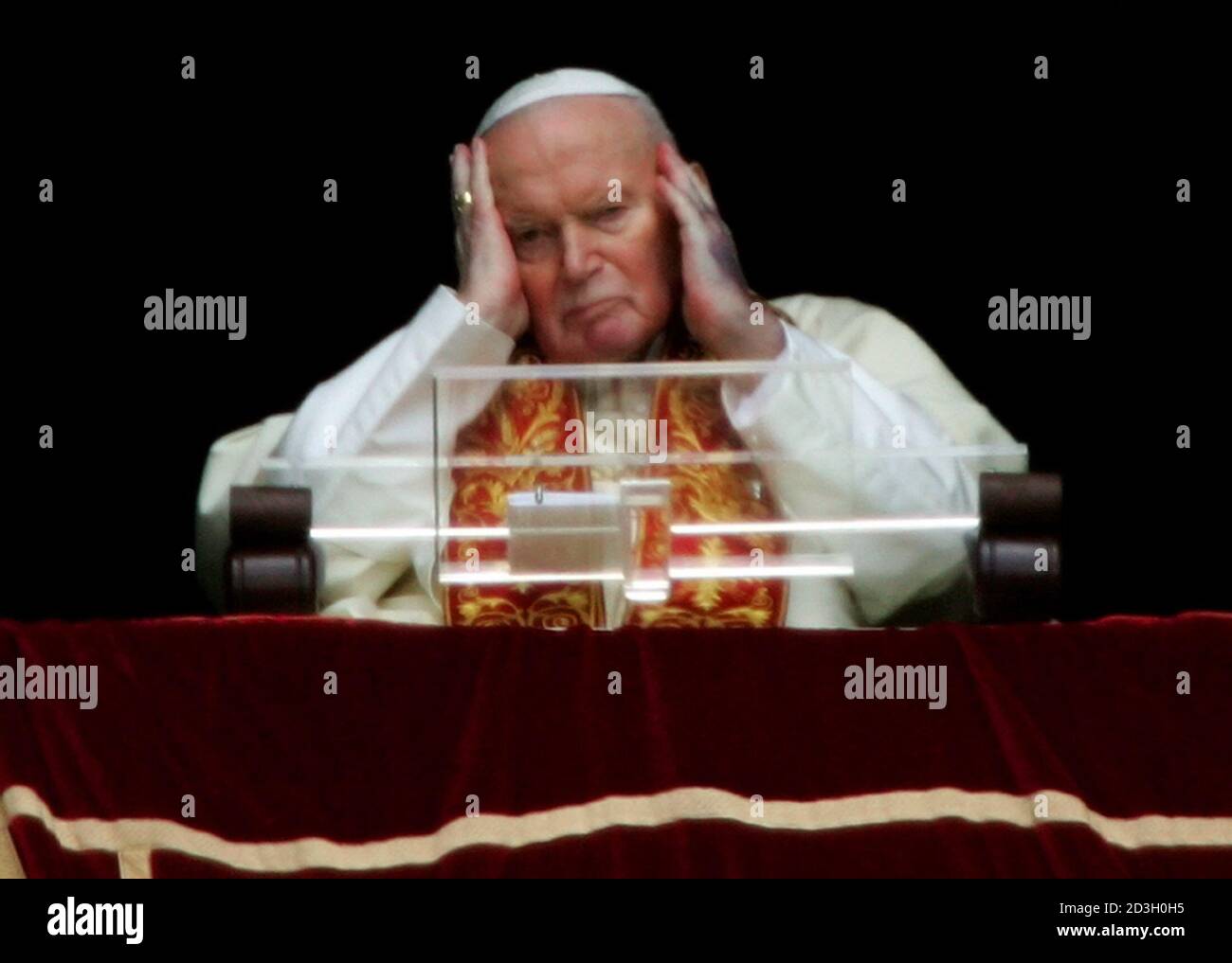 Pope John Paul II touches his head as he appears from the window of his  private apartments at the Vatican. Pope John Paul II touches his head as he  appears from the