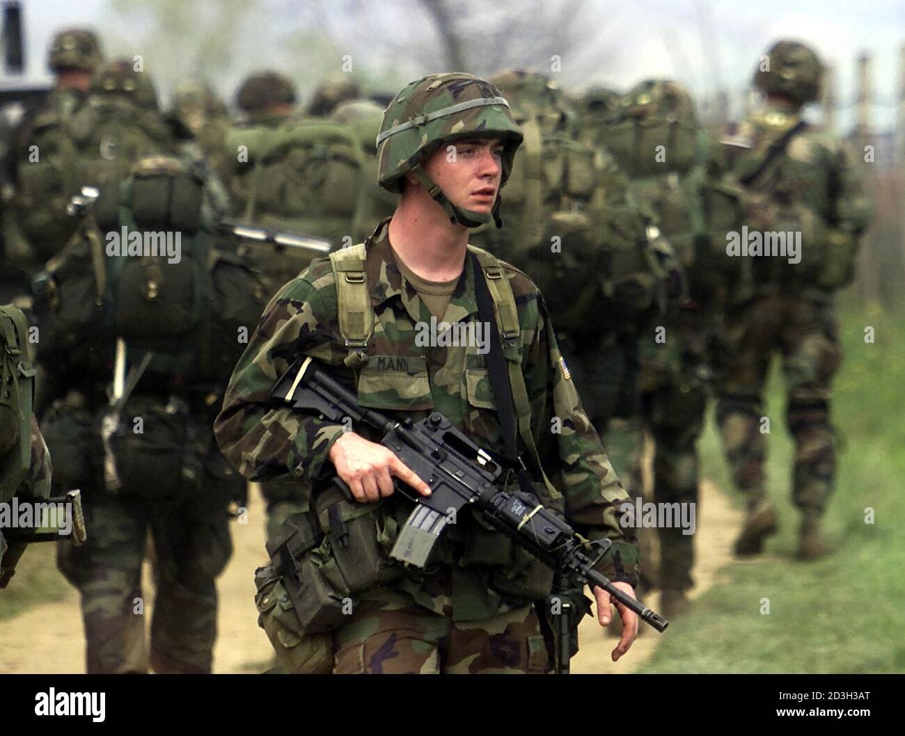 A U S Army Soldier From 173d Airborne Brigade From Southern European Task Force Turns To Cover The Back Of His Fellows April 27 2001 After Being Parachuted Near Vitina In Southern Kosovo