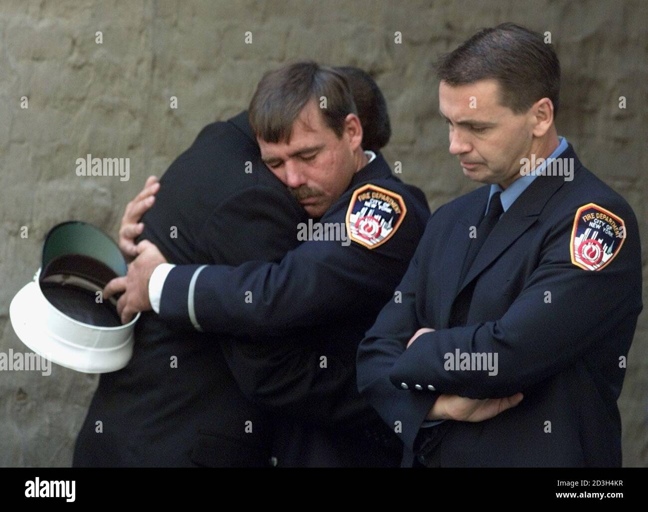 Fire fighters from Ladder Company 24 Engine 1 embrace outside of St. Francis of Assisi Church following the funeral of New York Fire Department Chaplain Reverand Mychal Judge in New York September 15, 2001. Chaplain Judge died while giving last rites to a fallen fire fighter after the collapse of the World Trade Center September 11. REUTERS/Rick Wilking  GMH/ME Stock Photo