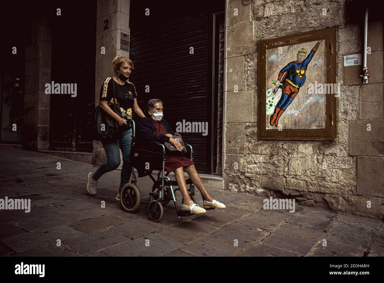 Barcelona, Spain. 8th Oct, 2020. Commuters pass a graffiti by Italian urban artist 'TVBoy', Salvatore Benintende, titled 'What doesn't kill you makes you stronger. Or not?' depicting US President Donald Trump wearing a Superman costume flying amid coronavirus clouds after his return to the white house while still suffering from the disease Credit: Matthias Oesterle/Alamy Live News Stock Photo