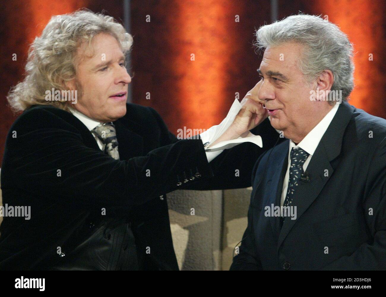 TV host Gottschalk adjusts the earphone of Spanish tenor Placido Domingo  during German television show 'Wetten Dass...?' in Hanover. TV host Thomas  Gottschalk (L) adjusts Spanish tenor Placido Domingo's earpiece during the