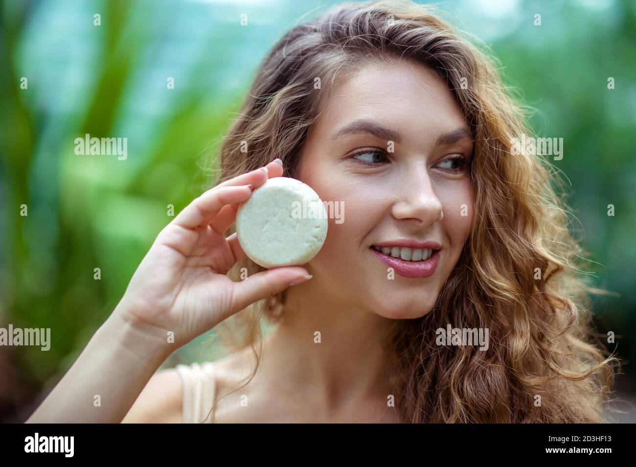 Pretty young woman with long hair holding a bar of soap Stock Photo - Alamy