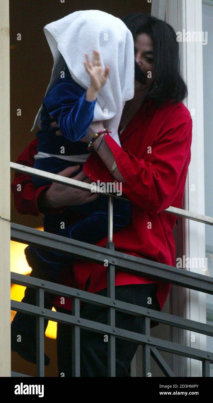 Entertainer And Popstar Michael Jackson Is Hugged By An Unidentified Child Covered With A Towel Who Waves To Fans From The Third Floor After Their Arrival At The Hotel Adlon In Berlin