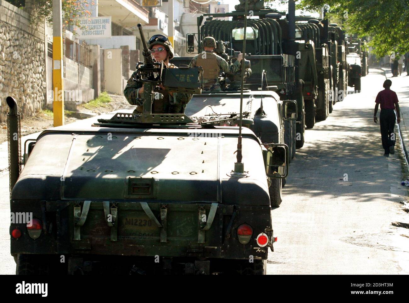 A U.S. Marine convoy patrols the streets of Port-au-Prince, Haiti, March 4, 2004. U.S. Marines are in Haiti to form part of an international effort to stabilize the country which has suffered chaos and anarchy as an armed rebellion forced President Jean-Bertrand Aristide to step down and flee the country. REUTERS/Andrew Winning  AW/GAC Stock Photo