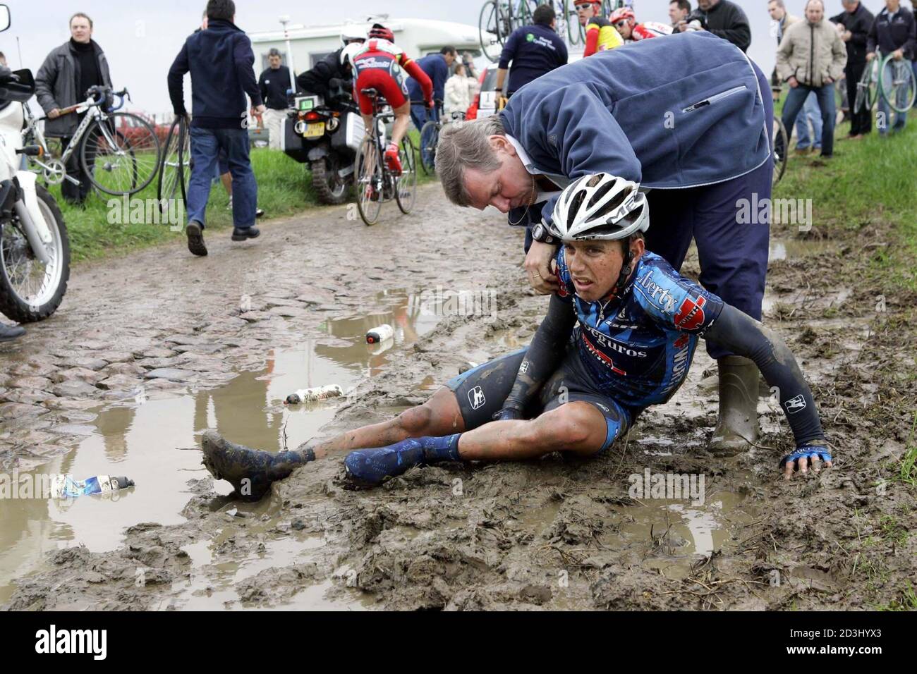 Allan Davis of Australia is assisted by French doctor Pascal Porte as he  lies in the mud after falling in the classical Paris-Roubaix cycling race  April 10, 2005. Tom Boonen won the