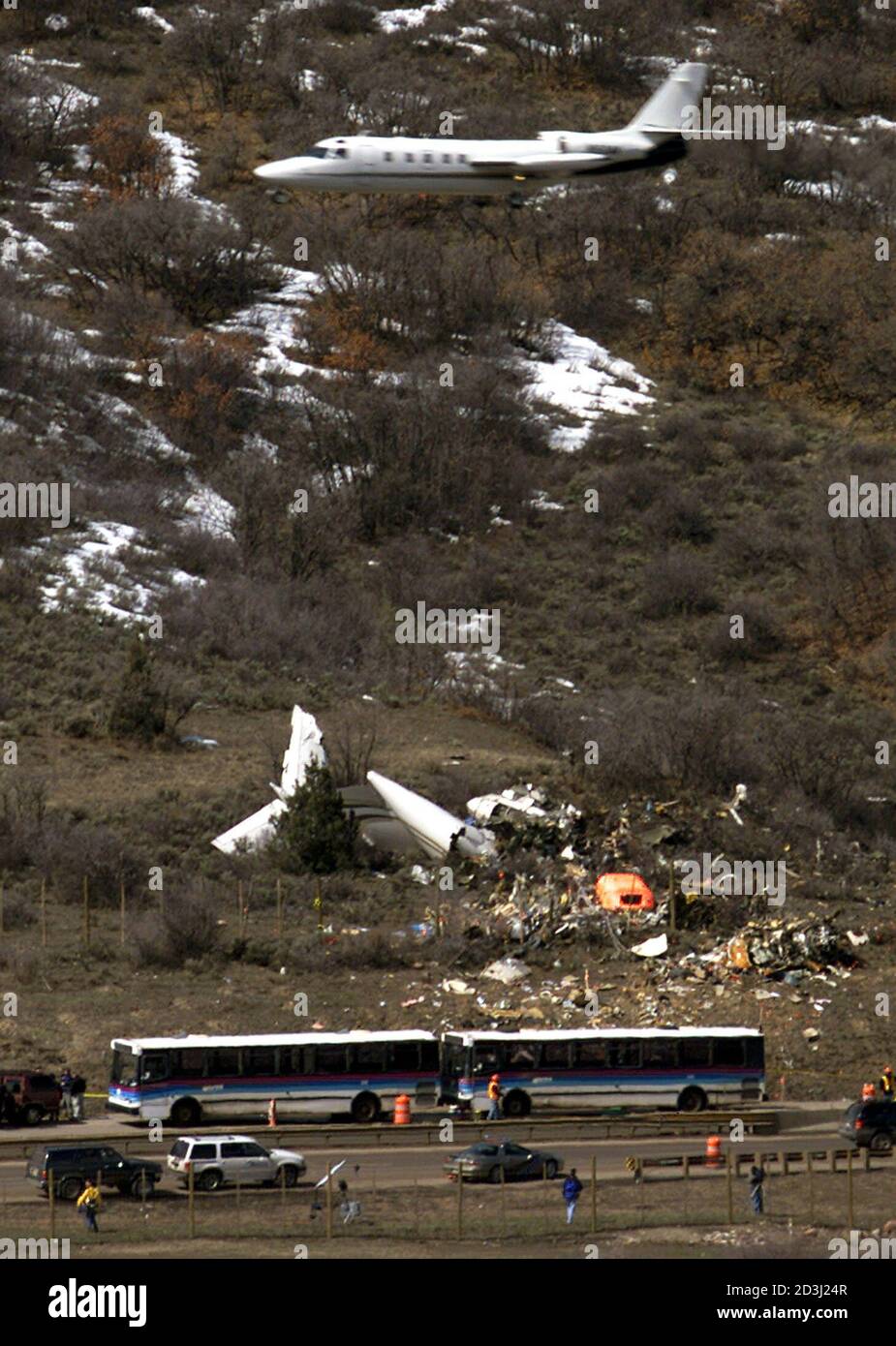 A plane descends to land at the Aspen/Pitkin County airport with a grim  visage of jet crash site below in Aspen, Colorado, March 30, 2001. A  Gulfstream corporate jet crashed on landing