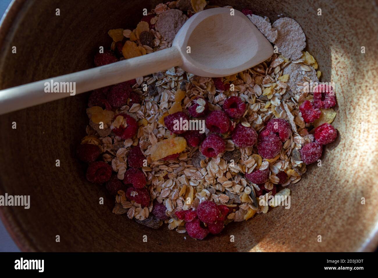 cereal bar ingredients in bowl with a wooden spoon . top view . Stock Photo