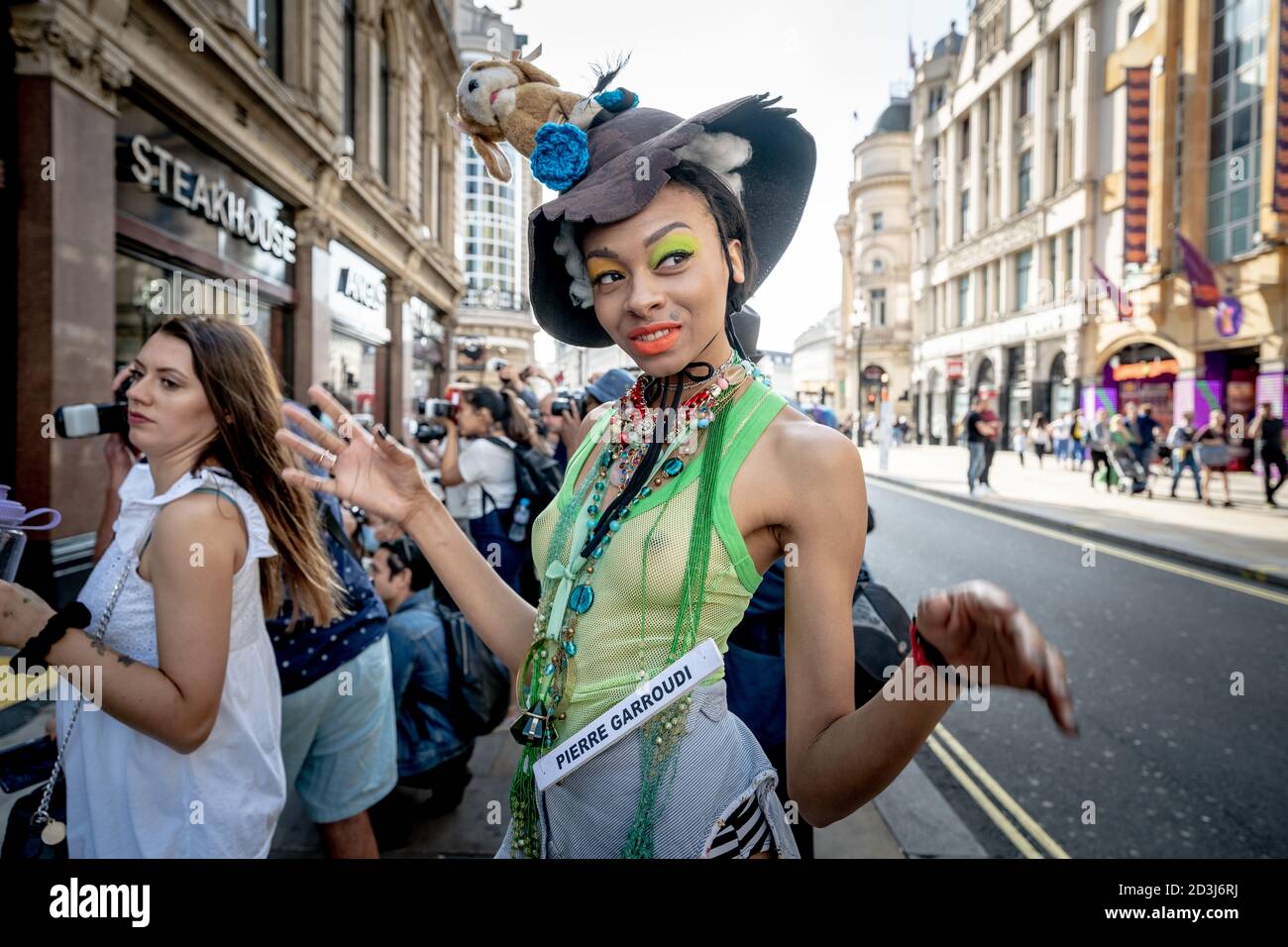 Models take part in a colourful flashmob street fashion show near Leicester Square for designer Pierre Garroudi. London, UK. Stock Photo