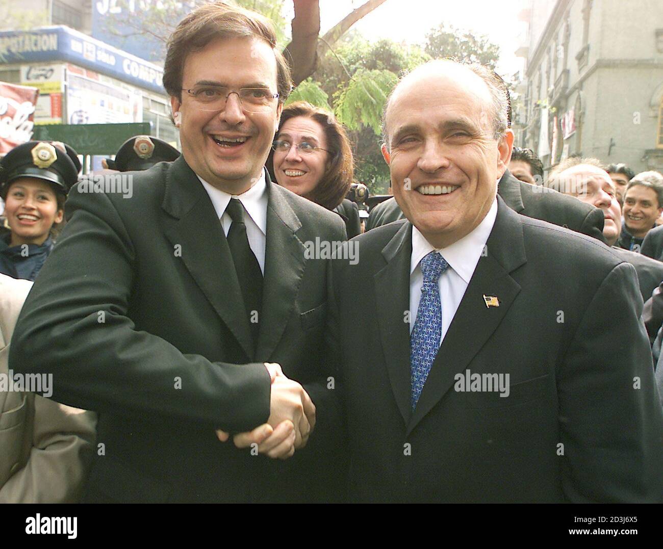 Former New York Mayor Rudy Giuliani (R) shakes hands with Mexico City's police chief Marcelo Ebrad during a tour along a street in a popular Mexico City district on January 14, 2003. Famed for taming the wild streets of New York in the 1990s with his 'zero tolerance' crime policy, Giuliani has been hired for $4.3 million by a group of prominent Mexican businessmen to reduce Mexico City's dizzying crime rate. REUTERS/Daniel Aguilar  DA Stock Photo