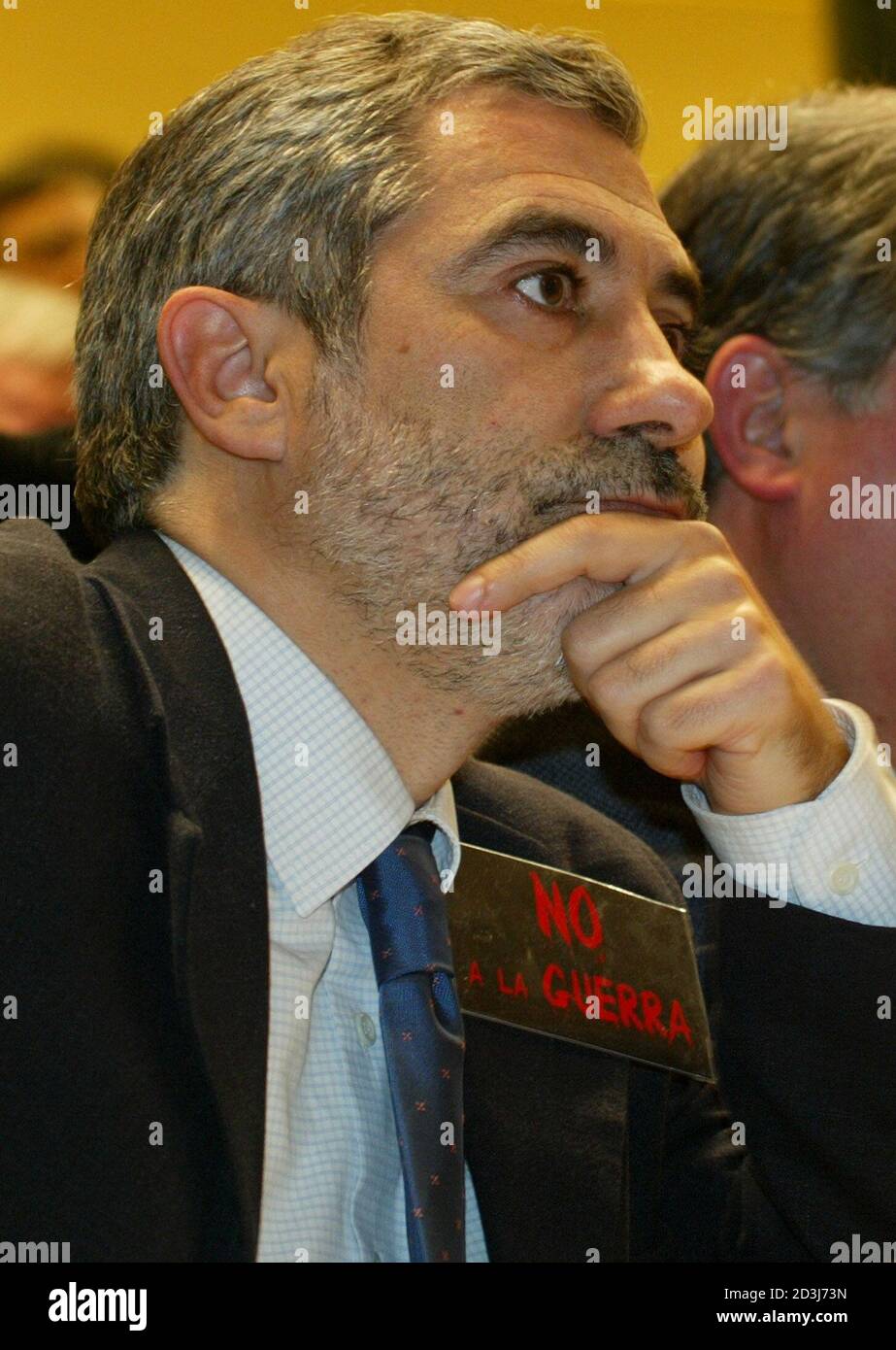 Spanish United Left party leader Gaspar Llamazares wears a 'No to war' badge as he listens to prime Minister Aznar's speech backing a U.S and British invasion of Iraq on February 5, 2003. Six members of parliament from the United Left party held up 'No to war' posters in the chamber before and after Aznar's speech in silent protest against government policy and later a group of well-known actors were shepherded out of the public gallery after displaying t-shirts bearing the same slogan. REUTERS/Desmond Boylan  DB Stock Photo