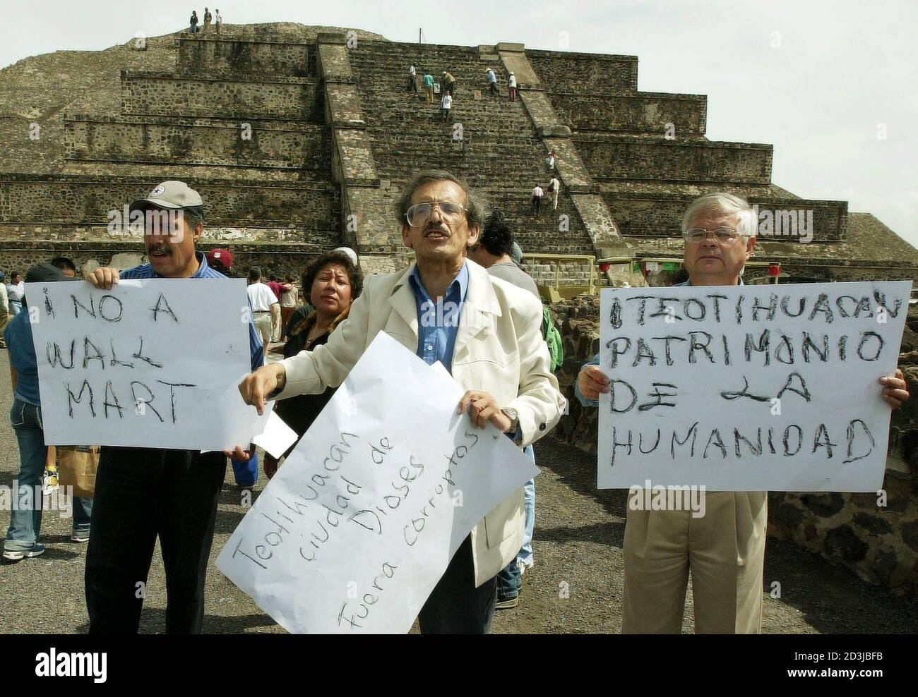 Mexican demonstrators protest against the construction of a Wal-Mart market, in front of the moon pyramid at Mexico's Teotihuacan archeological ruins on September 18, 2004. In the shadow of colossal pyramids left by a great Mexican civilization, a Wal-Mart rises, and some locals have gone to court to overturn its approval. Local activists are fighting the warehouse style store, saying it threatens the ruins and will destroy local commerce and a way of life that dates back centuries. REUTERS/Daniel Aguilar  DA Stock Photo