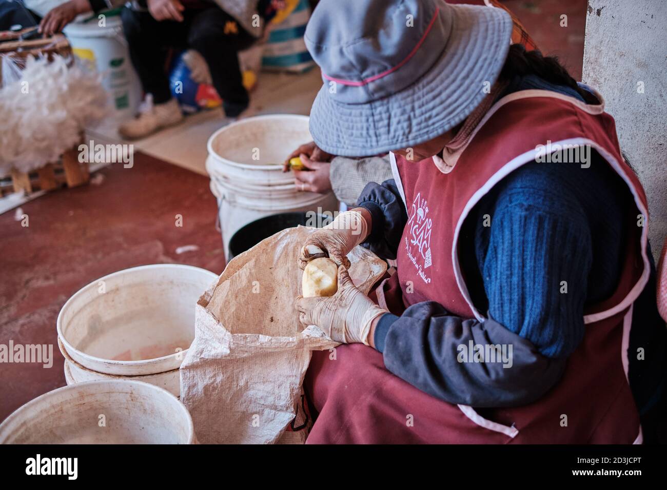 Peruvian women peeling potatoes in Pisac Pisaq Market, Peru Stock Photo