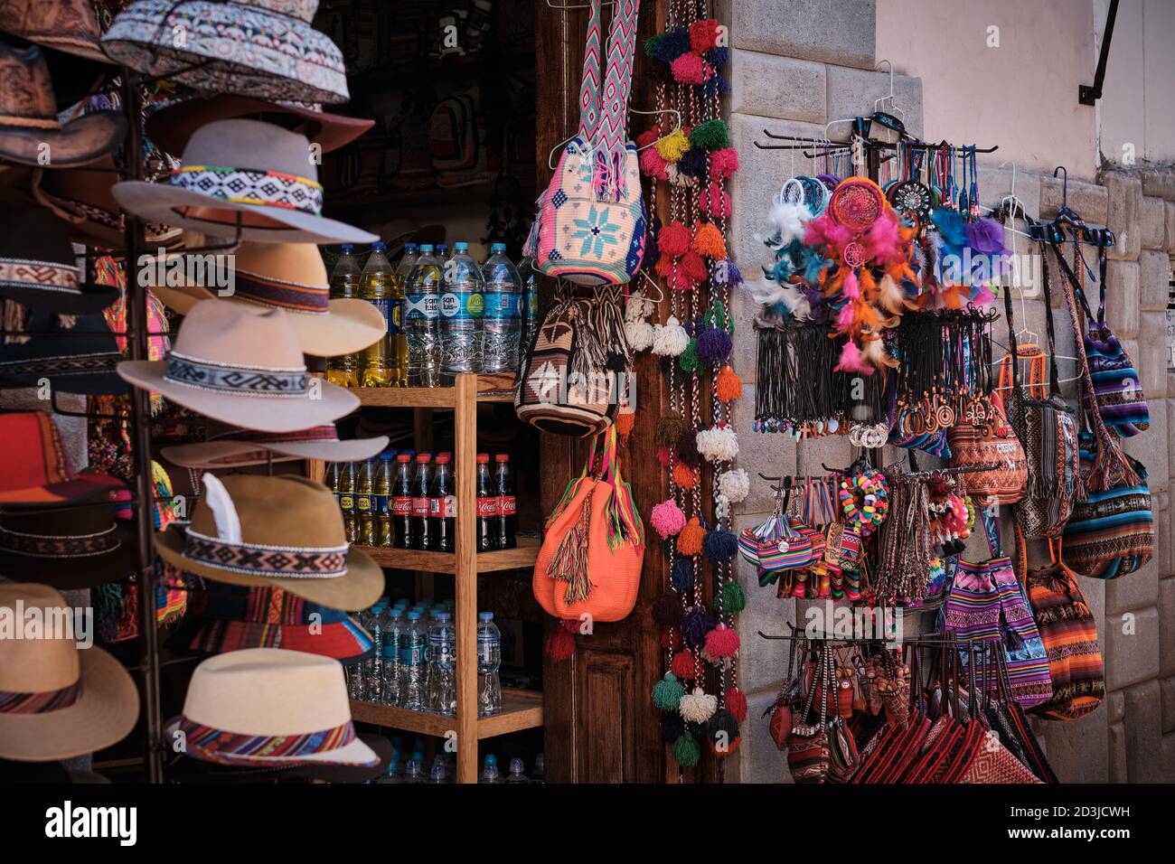 A market stall at Pisac Pisaq Market, Peru, selling novelty gifts, souvenirs, hats, and soft drinks Stock Photo