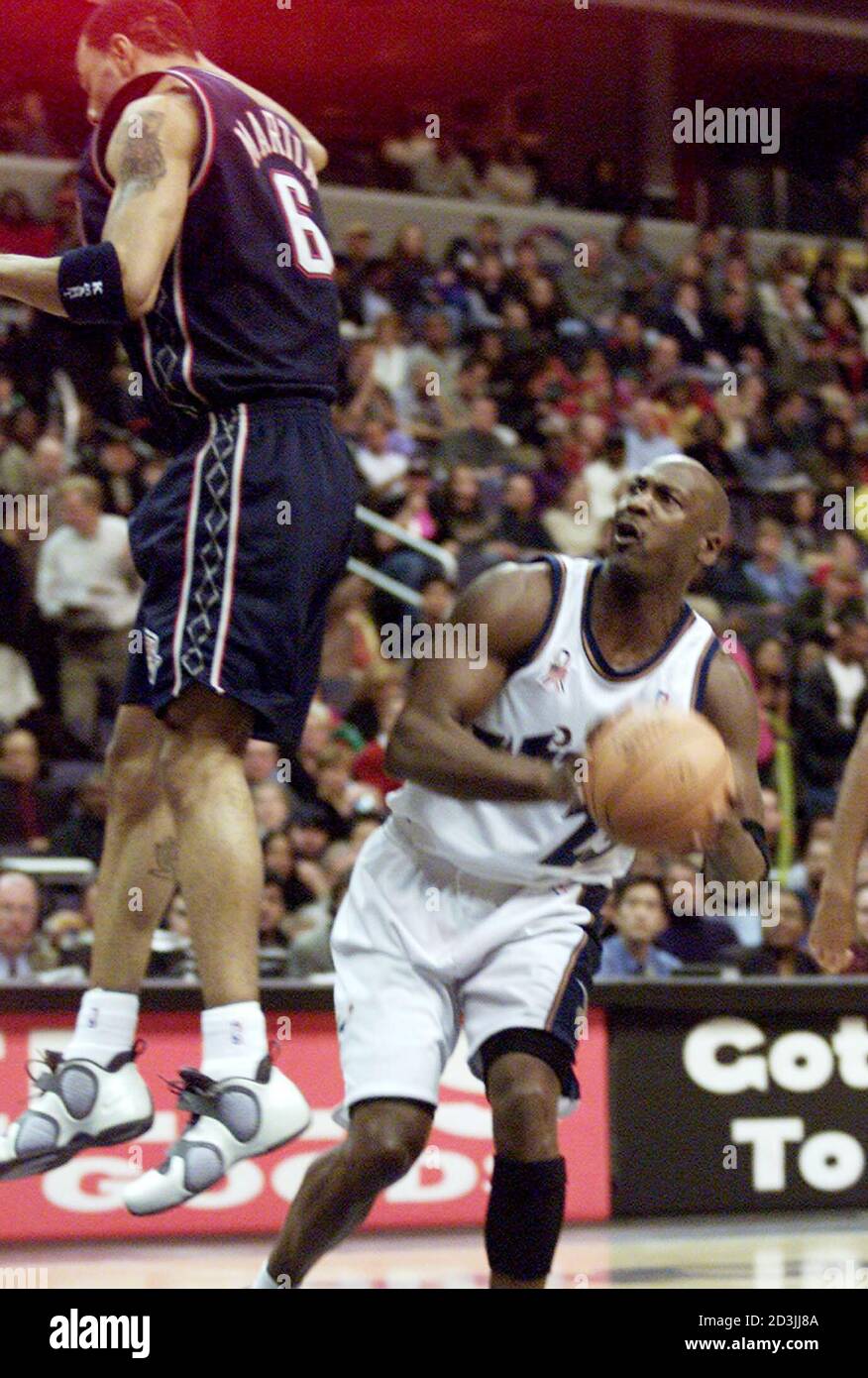 Washington Wizards' Michael Jordan (R) leaves New Jersey Nets' Kenyon  Martin hanging in the air as Jordan faked going up for a shot in the fourth  quarter of their game at the