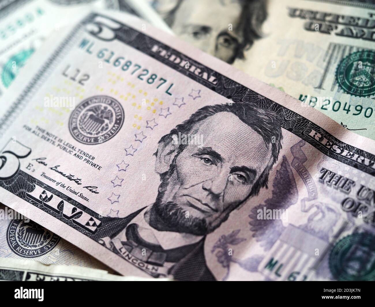 In this photo illustration a 5 dollar bill with various dollar bills. Stock Photo