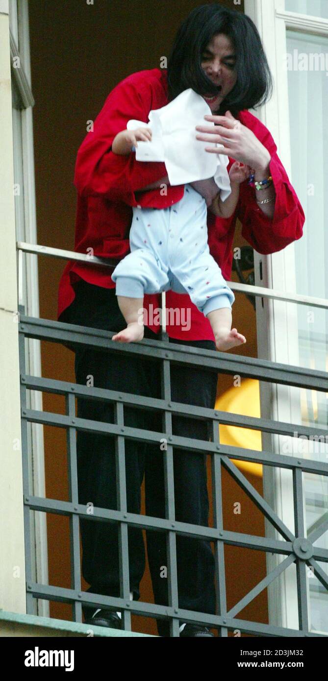 Entertainer And Popstar Michael Jackson Holds An Unidentified Child Who Is Covered With A Towel From A Third Floor Balcony After Their Arrival At The Hotel Adlon In Berlin November 19 02