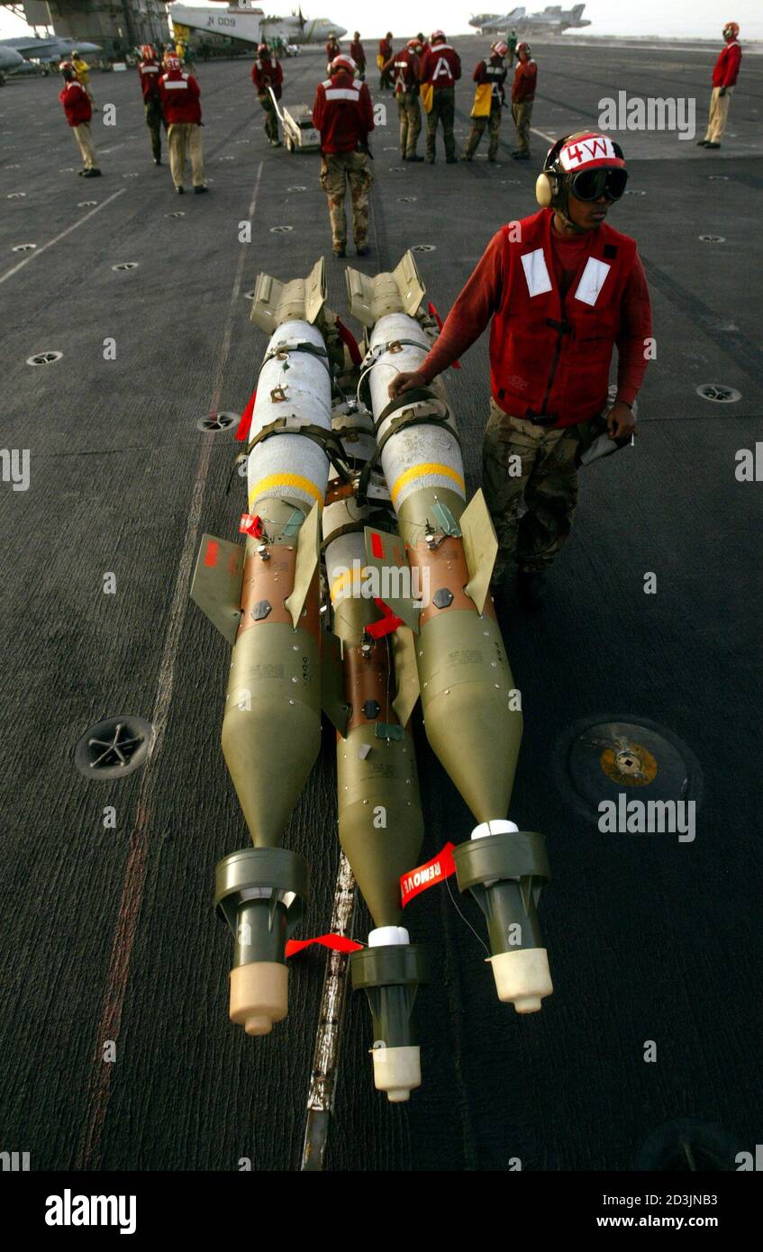 AN AVIATION ORDNANCEMAN STANDS NEXT TO LASER GUIDED BOMBS ABOARD THE USS KITTY HAWK AIRCRAFT CARRIER IN THE GULF. Stock Photo