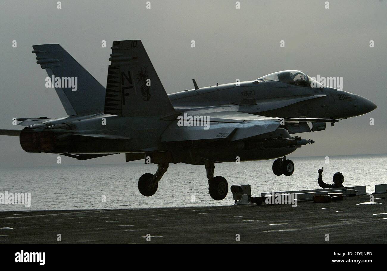 An aviation ordnanceman (R) gives a thumb up while a F/A-18 Hornet fighter jet takes off from the USS Kitty Hawk aircraft carrier in the northern Gulf April 11 2003. The carrier and its strike group is conducting mission in support of operation over Iraq. REUTERS/Yves Herman  HRM Stock Photo