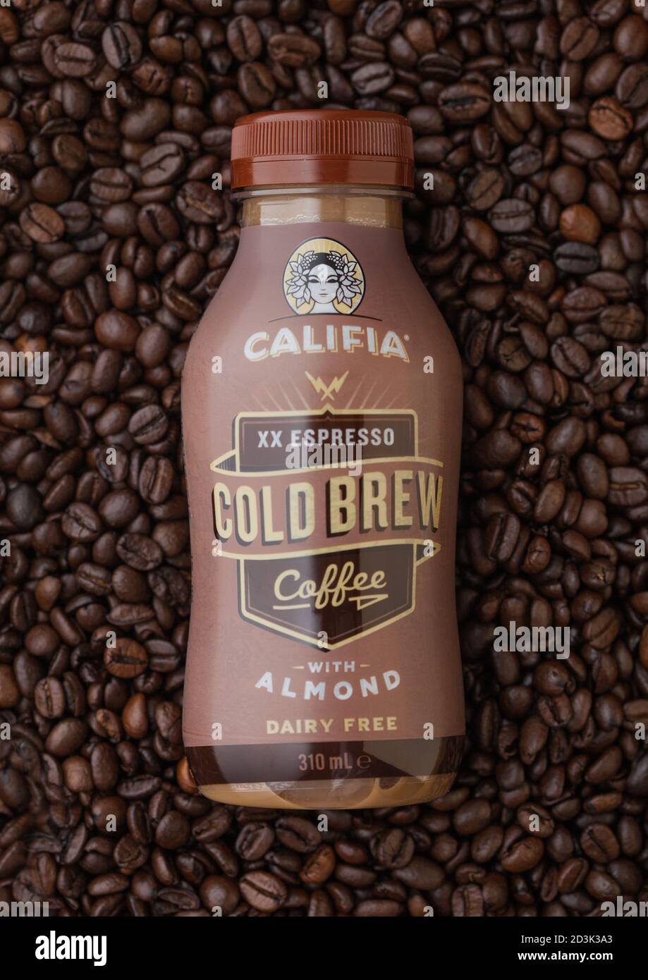 LONDON, UK - SEPTEMBER 09, 2020: Bottle of cold Califia espresso cold brew coffee with almonds on top of raw coffee beans. Stock Photo