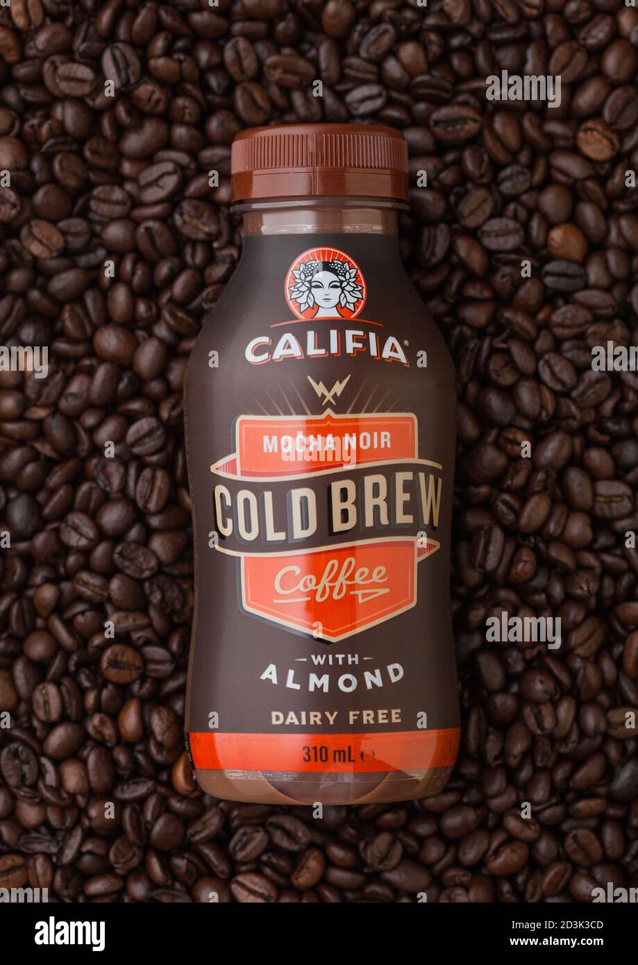 LONDON, UK - SEPTEMBER 09, 2020: Bottle of cold Califia mocha noir coffee with almonds on top of fresh raw coffee beans. Stock Photo