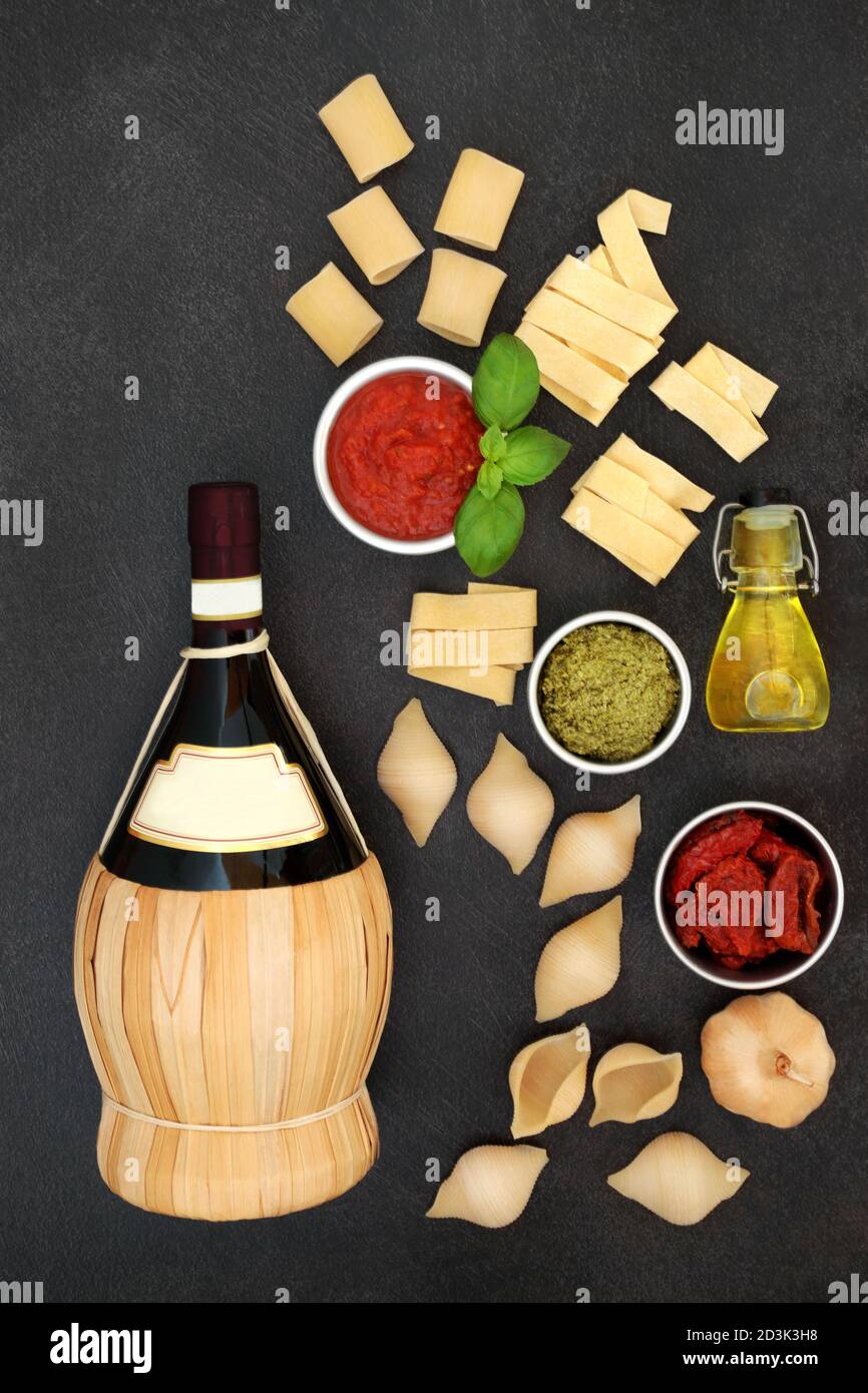 Classic Italian cuisine ingredients & red wine wicker bottle with various ingredients & dried