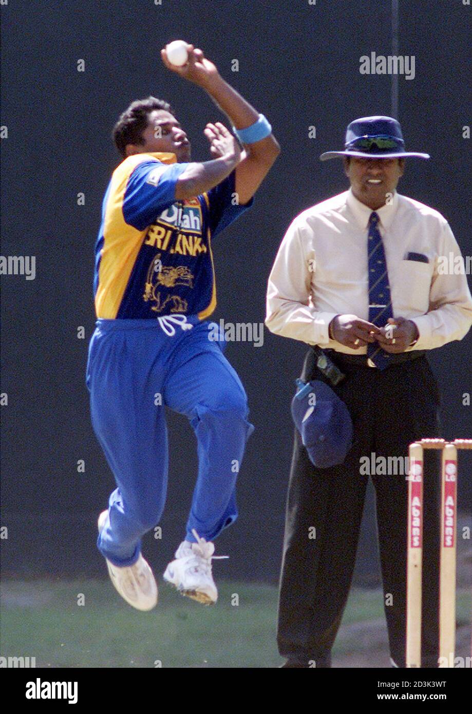 Sri Lankan fast bowler Chaminda Vaas (L) bowls against Zimbabwe as umpire Gamini Silva watches in the curtain raiser of the LG triangular tournament at Sinhalese Sports Club ground in Colombo on December 8, 2001. Vaas created a new world record by capturing eight wickets for 19 runs as the visitors were bowled out for 38 runs. Sri Lanka won the game by nine wickets. REUTERS/Anuruddha Lokuhapuarachchi  AL/RCS Stock Photo