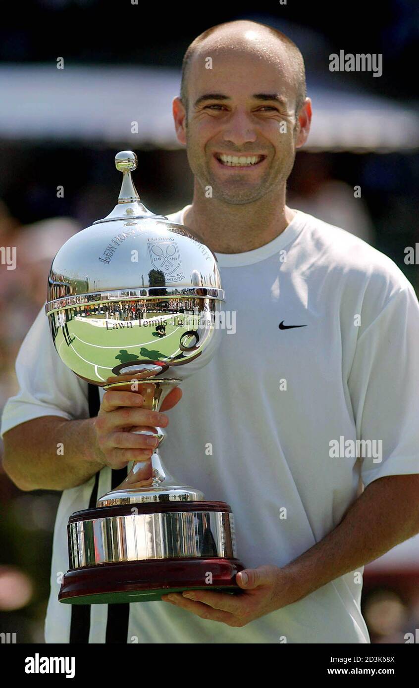 Andre Agassi of the United States holds the trophy after defeating  Sebastien Grosjean of France to win the Kooyong Classic in Melbourne  January 11, 2003. Agassi won the match 6-2 6-3. REUTERS/Jack