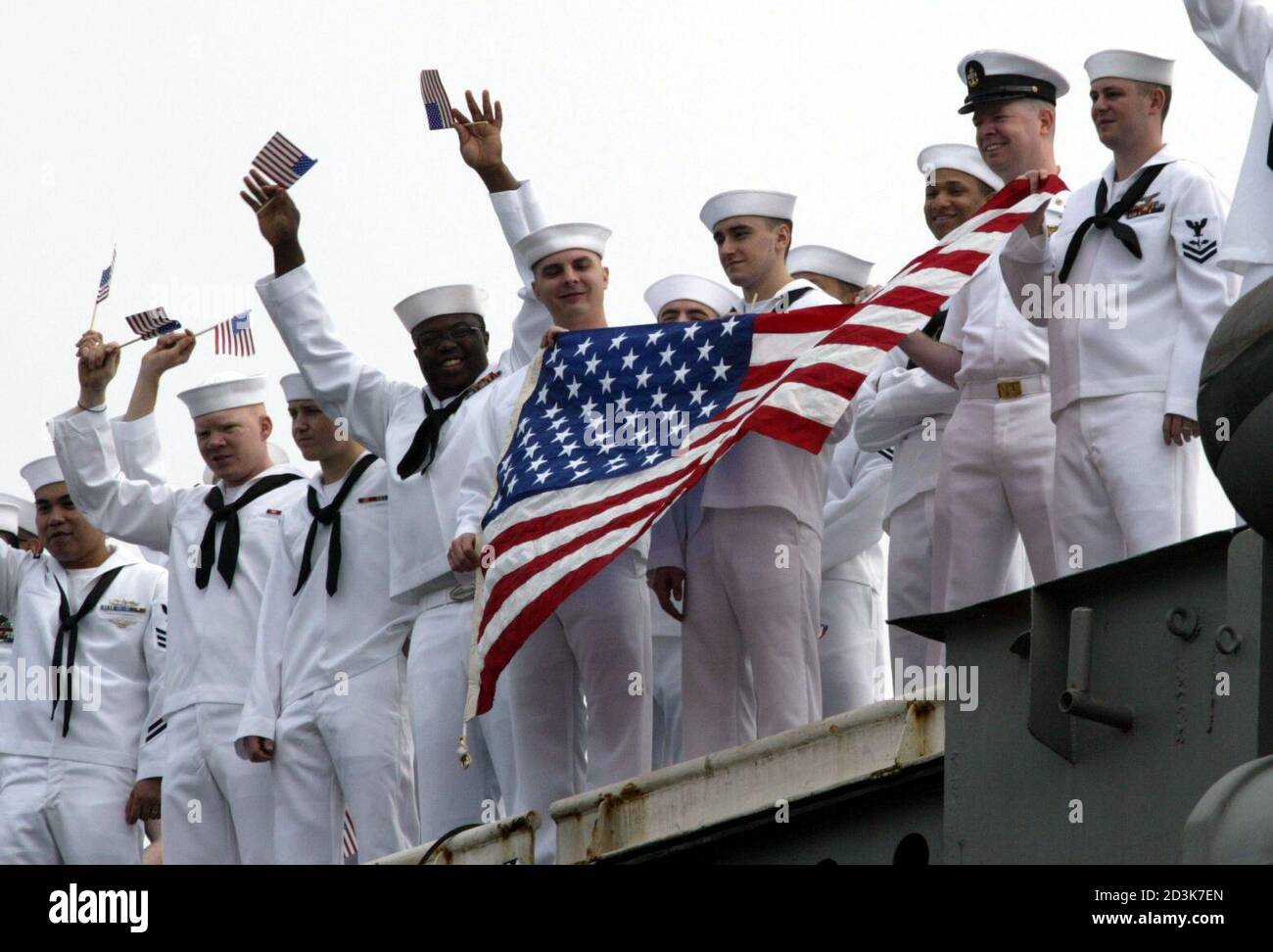 USS aircraft cerrier Kitty Hawk crew members wave as they arrive at the U.S. naval base in Yokosuka, south of Tokyo, May 6, 2003. The aircraft carrier returned to its forward deployed port on Tuesday after participating in Operations Southern Watch and Iraqi Freedom. REUTERS/Issei Kato  IK/RCS Stock Photo